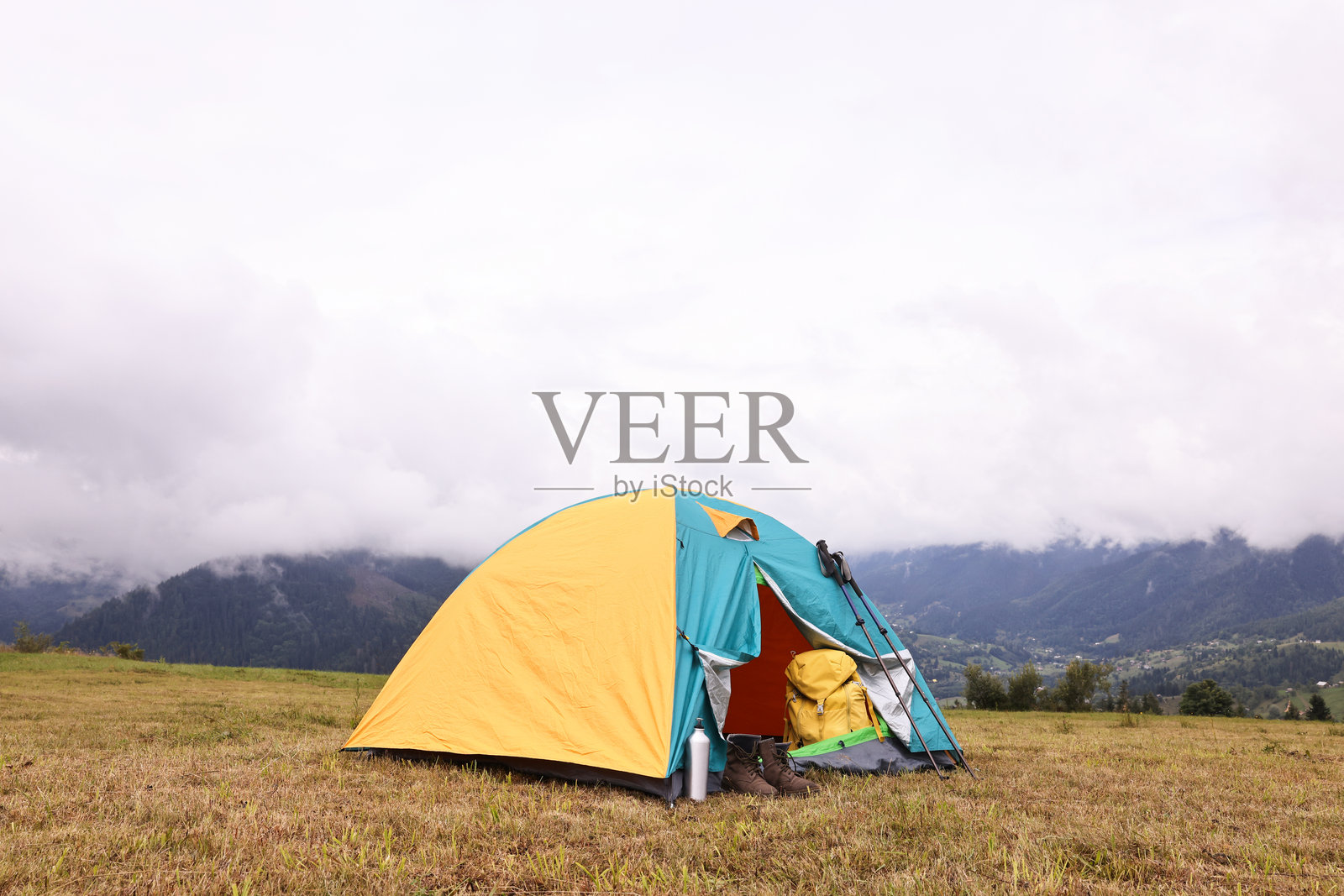 山中草地上的露营帐篷和旅游用品照片摄影图片