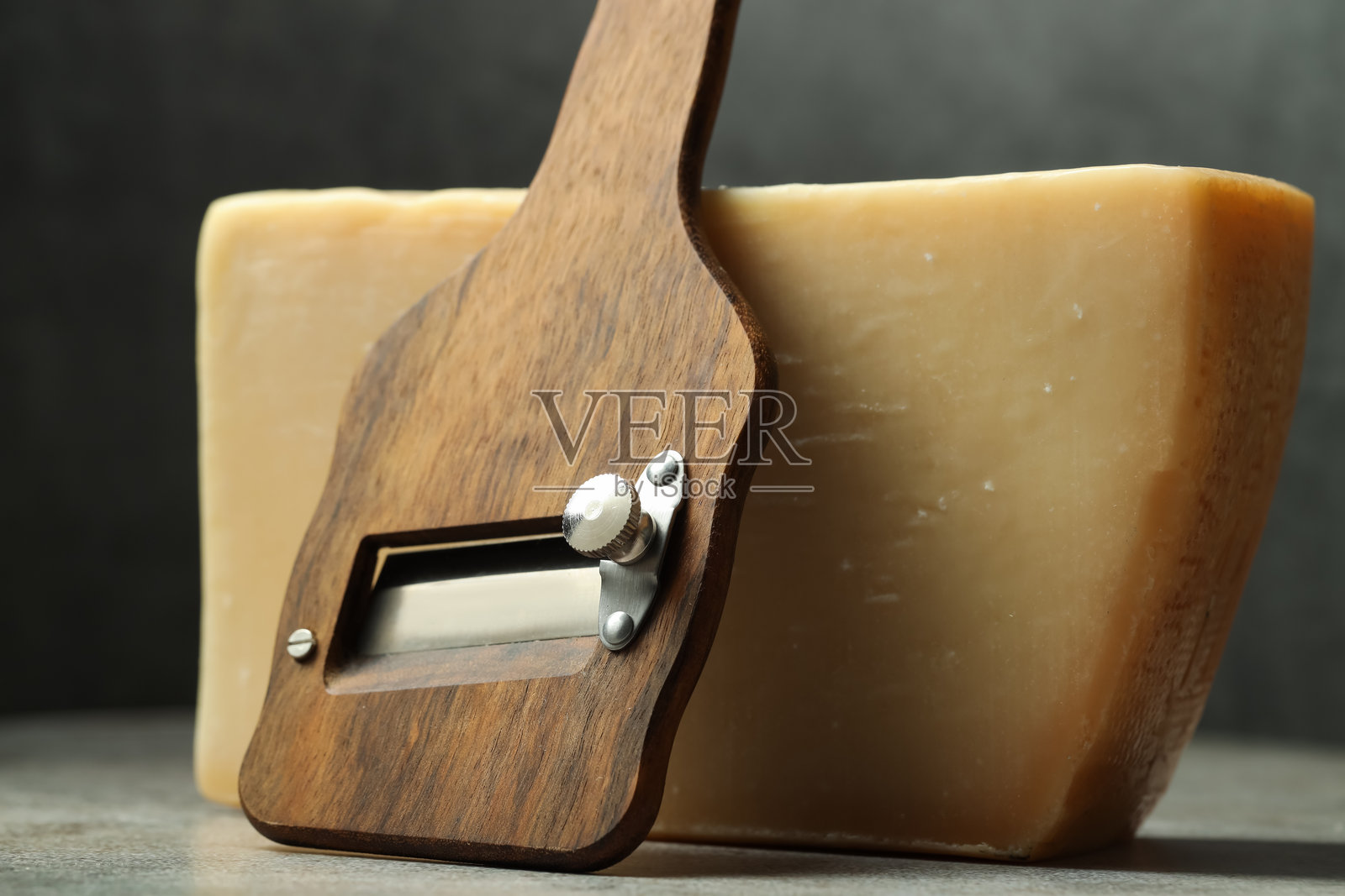 美味的奶酪和切片器放在灰色桌子上，特写镜头照片摄影图片