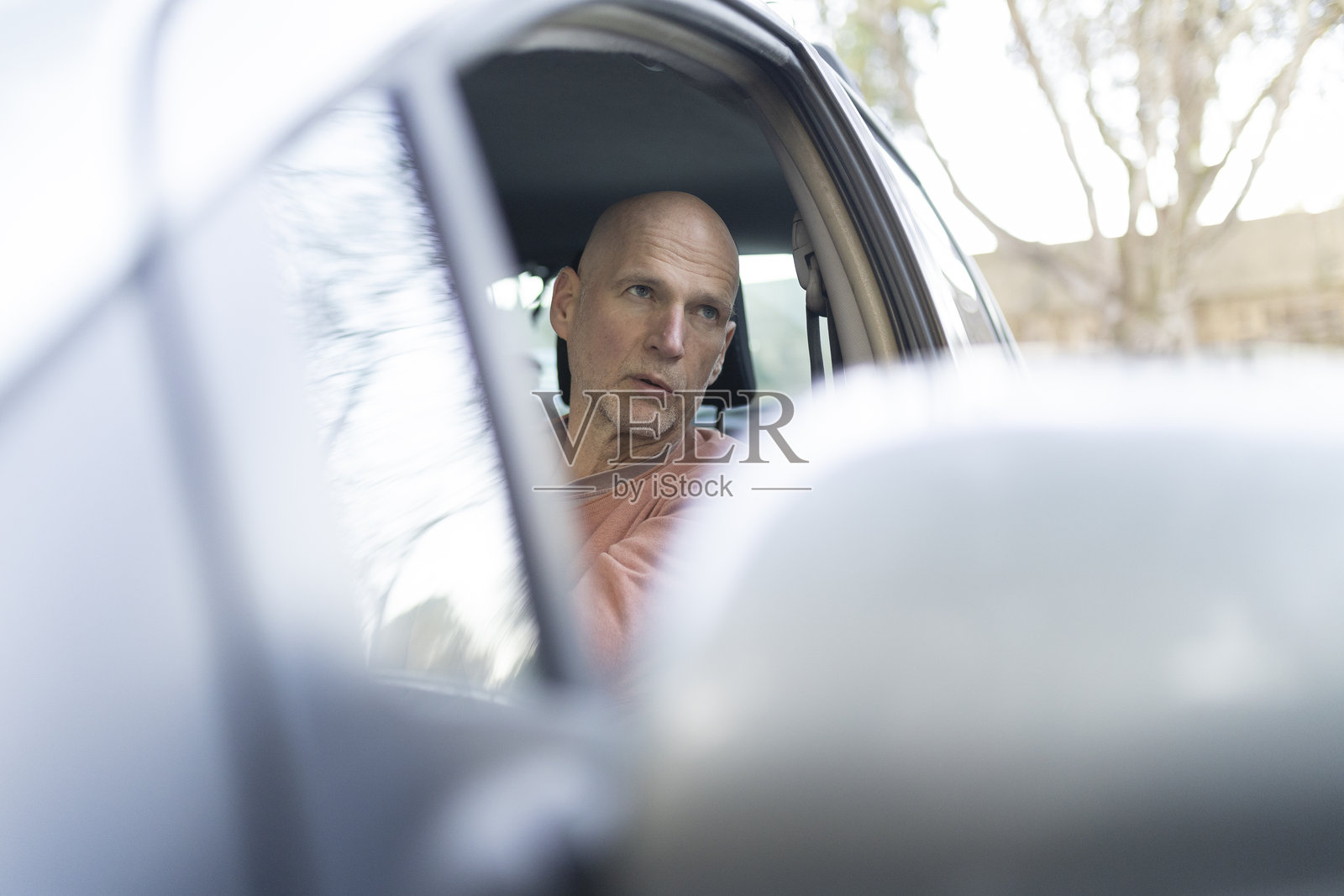 成熟男性驾驶汽车，沉思地望向窗外照片摄影图片