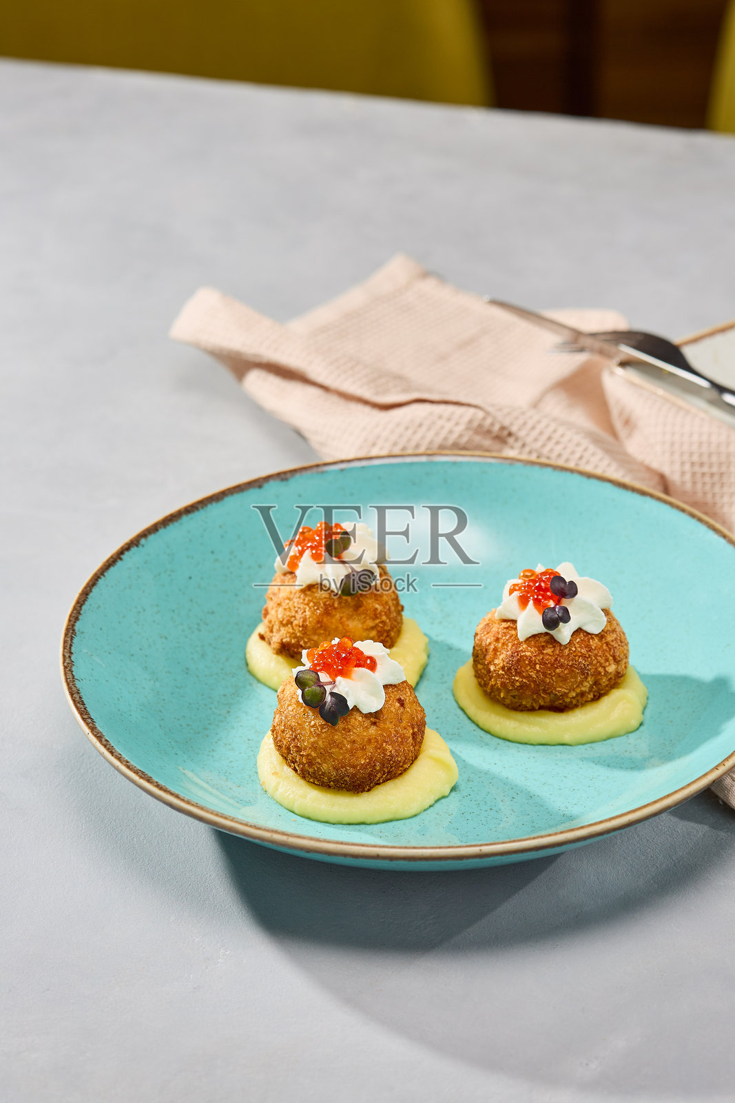 艺术化的鱼饼呈现在奶油土豆泥上，配以生动的灯光和自然色调照片摄影图片