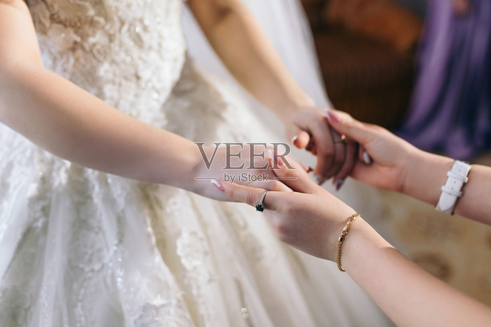 一位女性穿着婚纱，正与另一位女性牵手。两位女性面带微笑，似乎在享受彼此的陪伴。温暖与幸福的概念。照片摄影图片