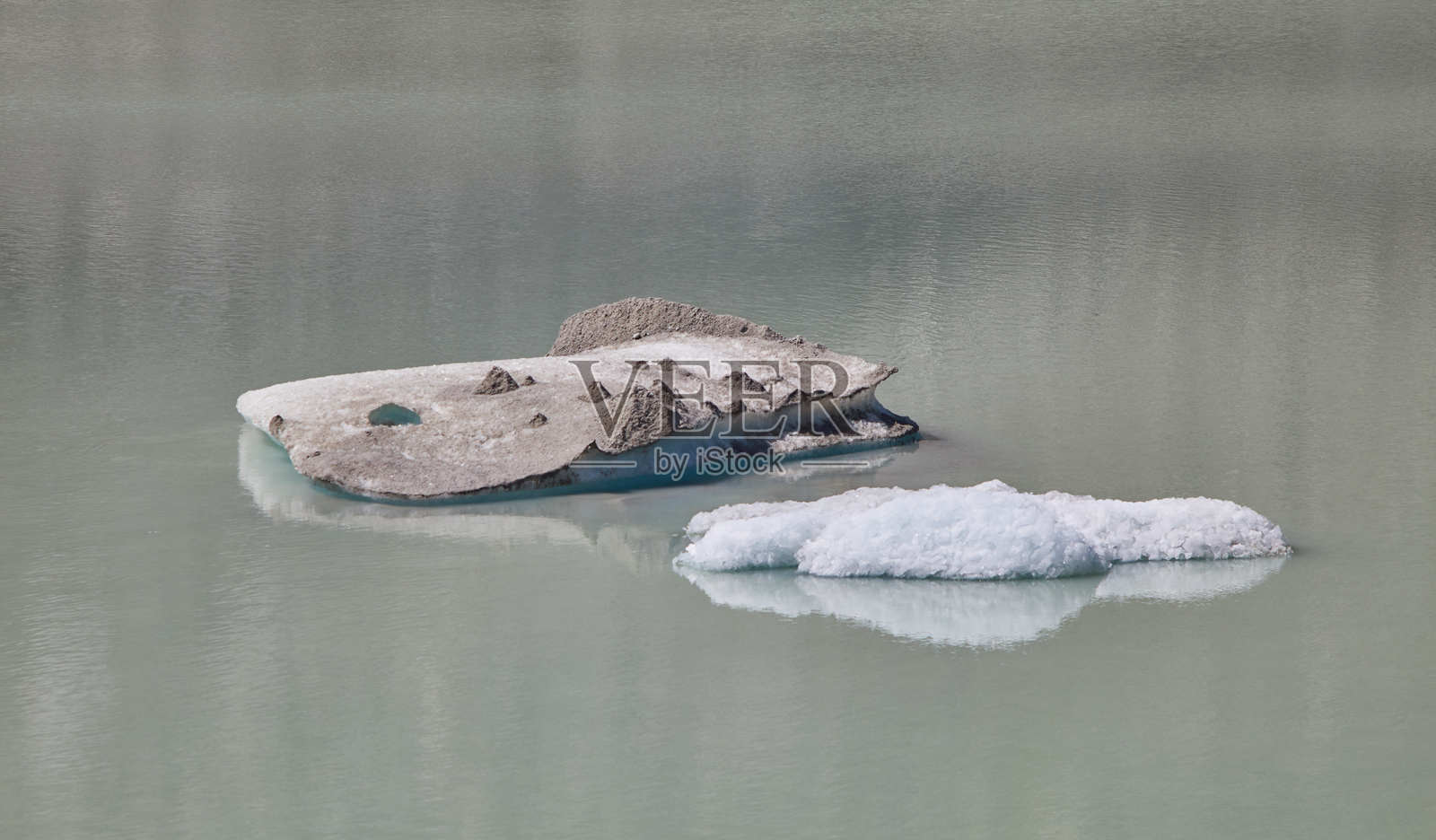 融化的冰川冰块漂浮在宁静的阿尔卑斯湖面上照片摄影图片