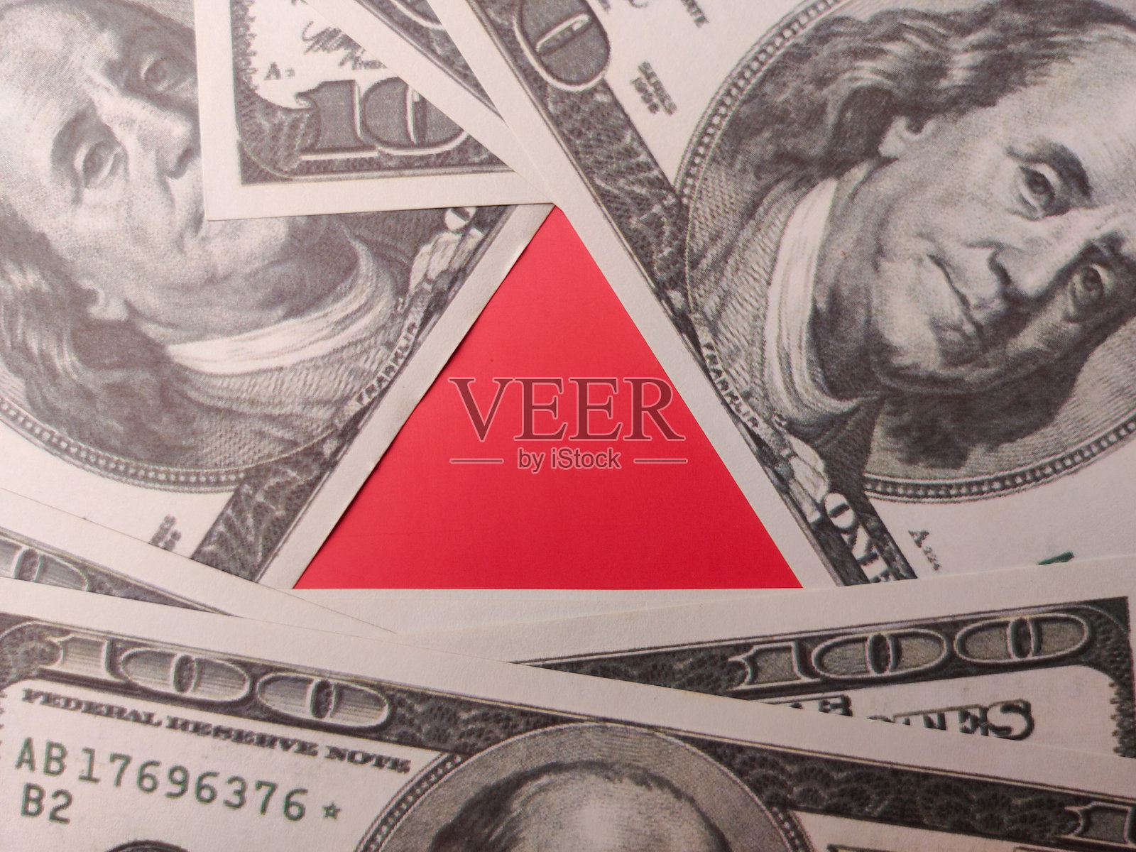 红色三角形位于一百美元的中间。照片摄影图片