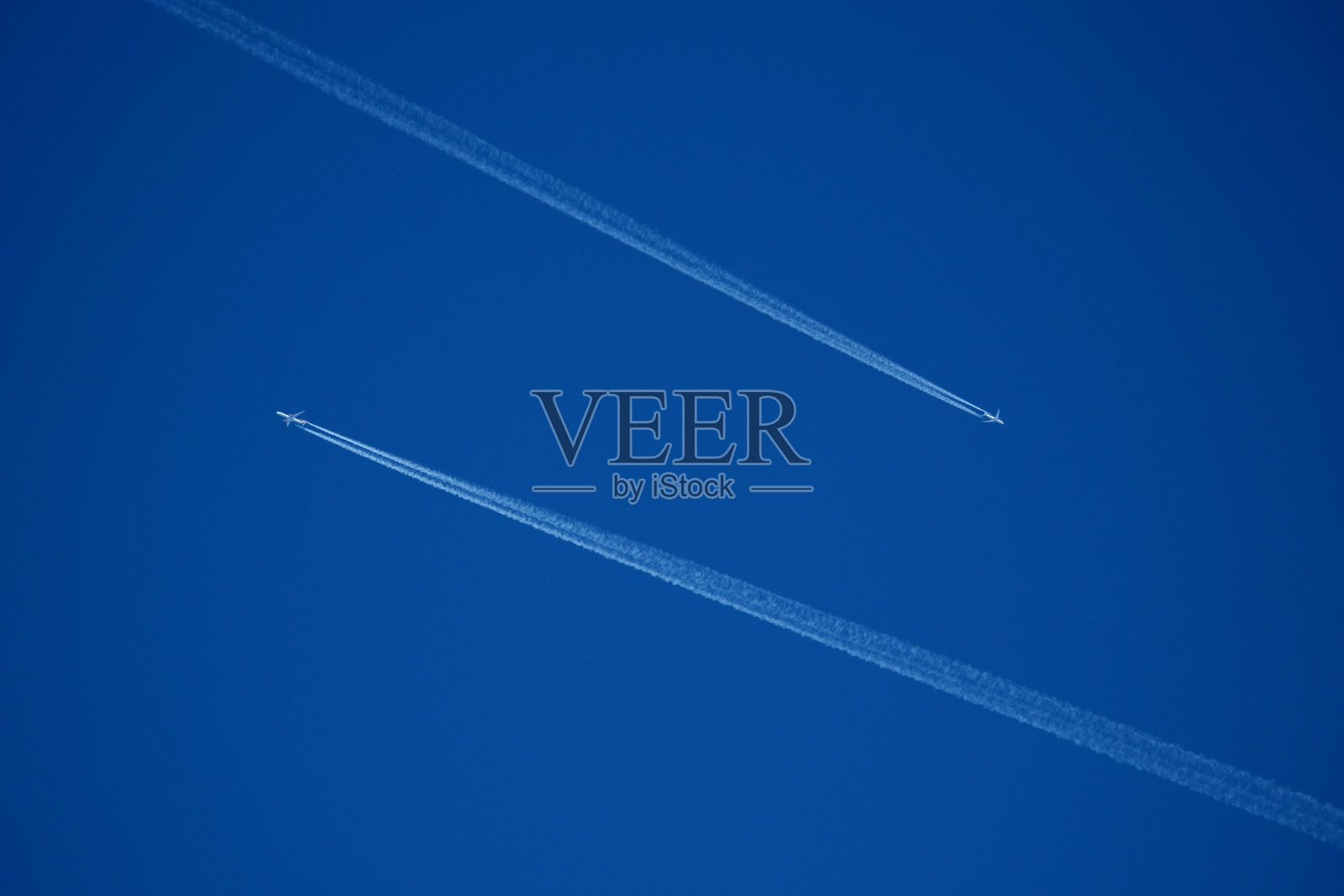 两条飞机尾迹。清澈蓝天中的飞机航迹照片摄影图片