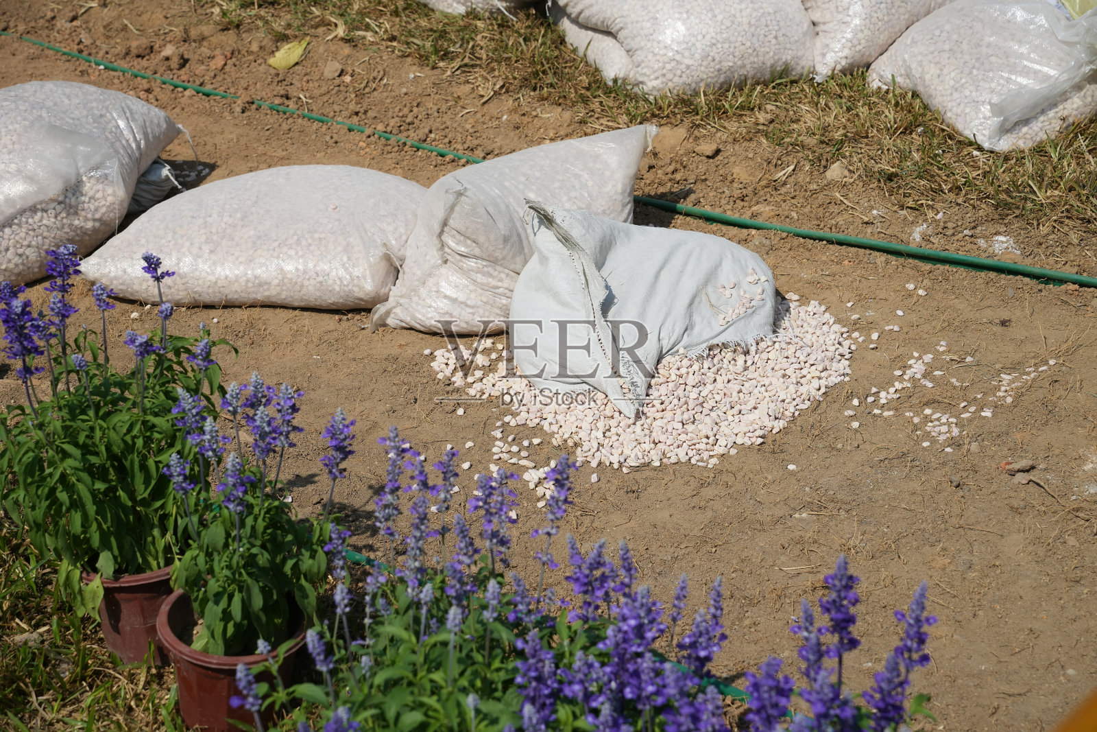 堆放在休闲公园内的装满园艺碎石的白色沙袋照片摄影图片
