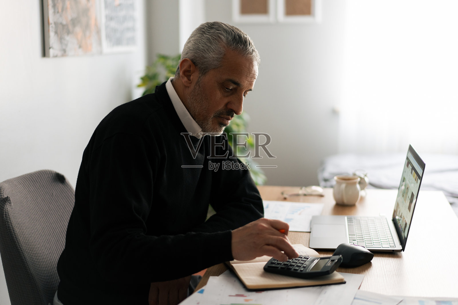 在家工作的老年人使用计算器照片摄影图片