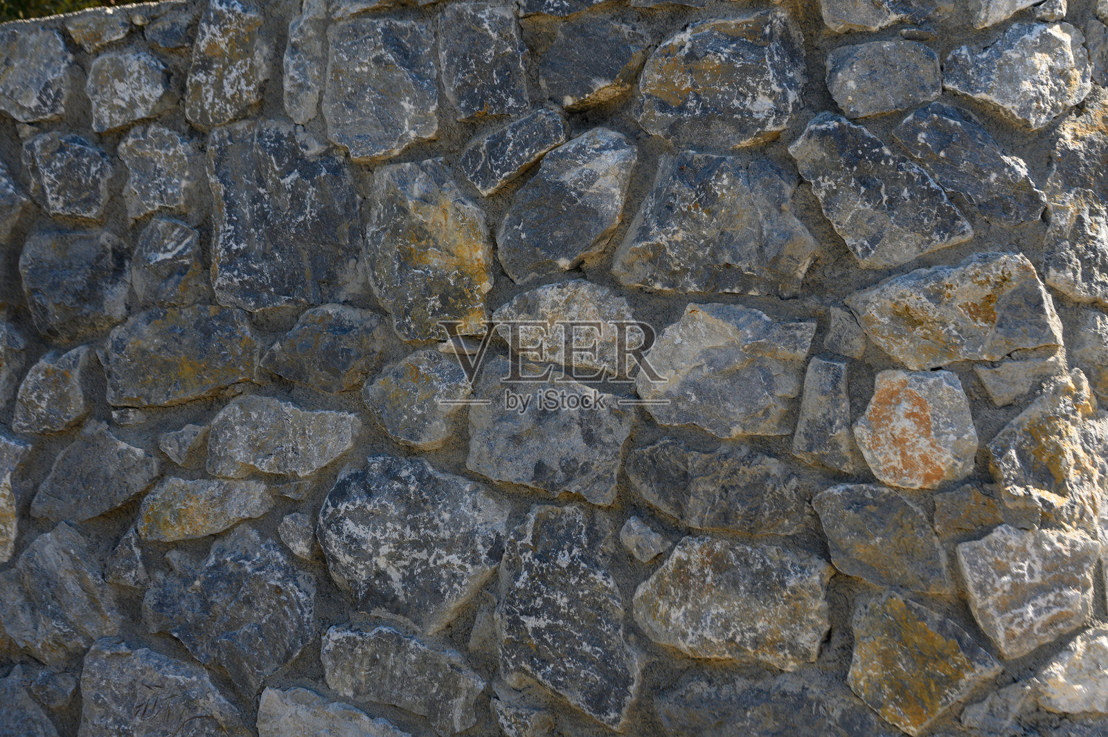 天然石墙为户外空间增添了乡村魅力，经过精美的风化，展现出独特的纹理和色彩变化。照片摄影图片