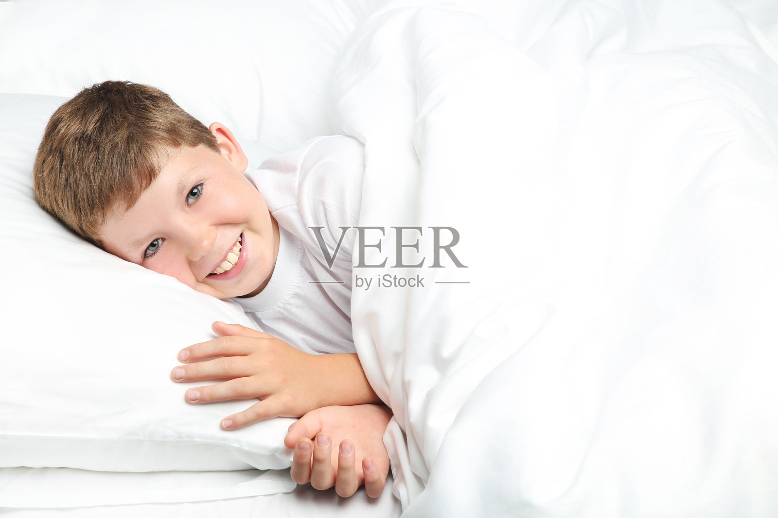 小男孩在白色床上睡觉照片摄影图片