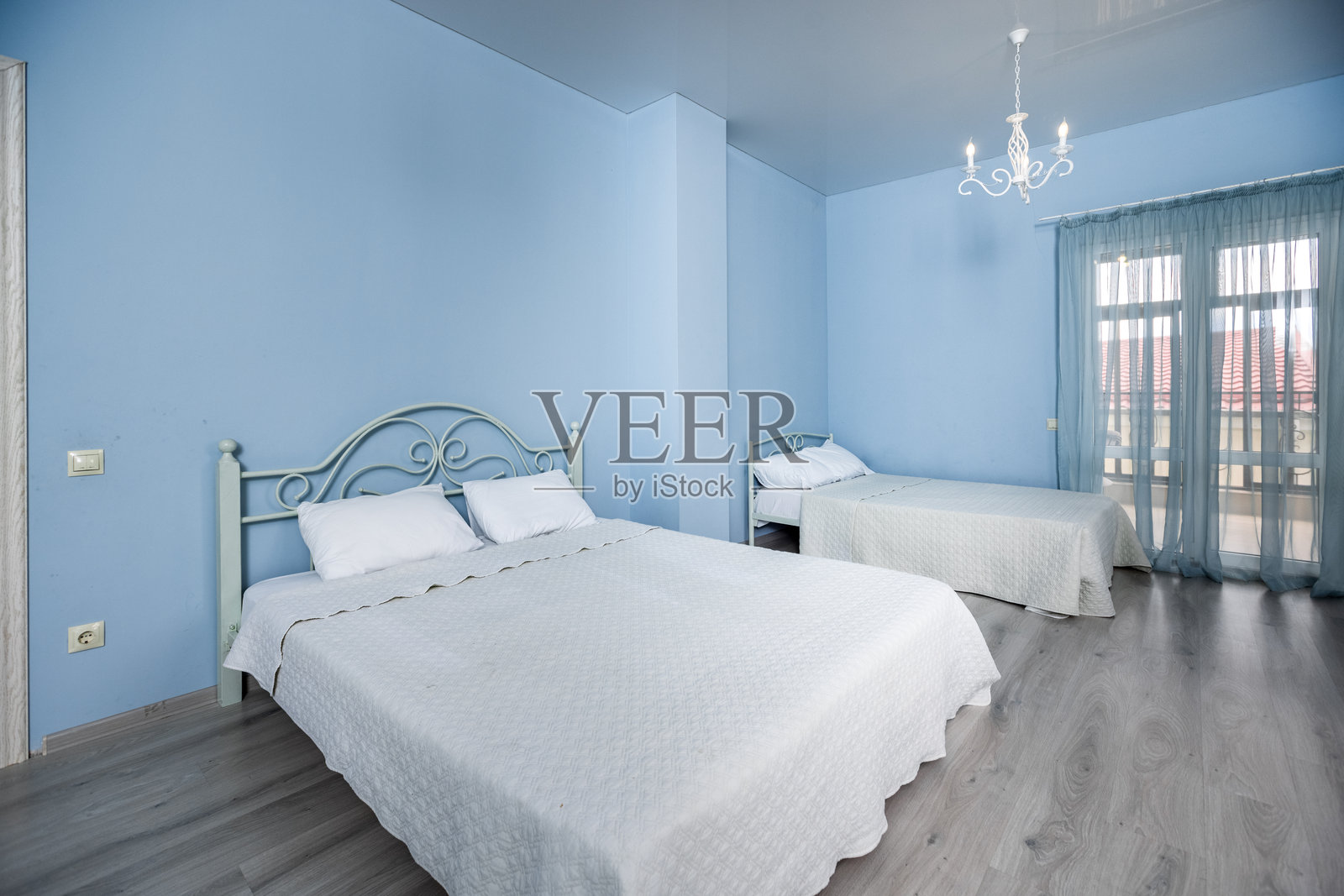 一间有白色床和白色窗帘的卧室照片摄影图片