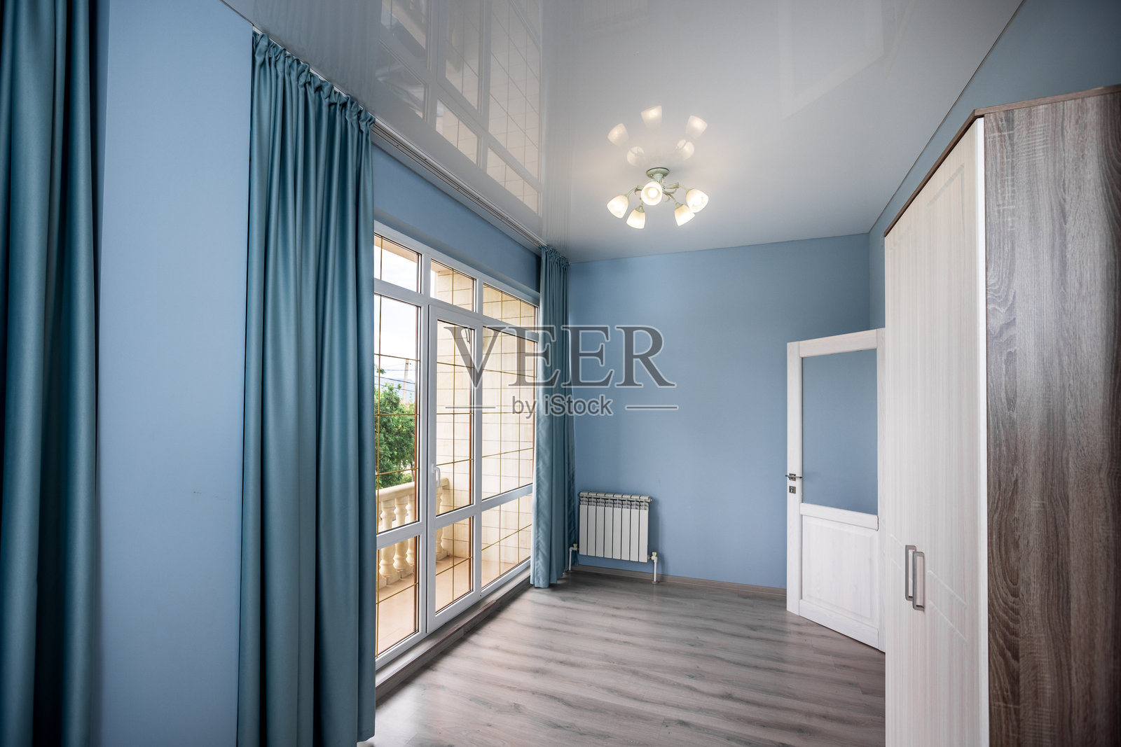 一间蓝色墙壁和白色窗帘的房间照片摄影图片