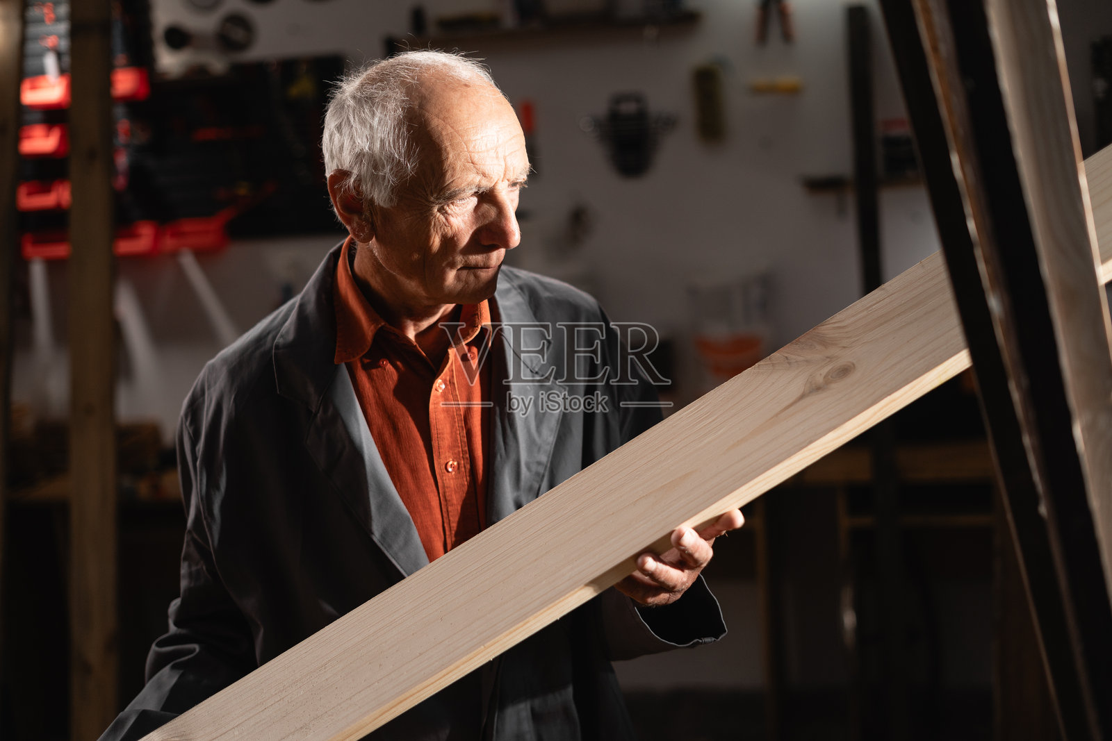 退休的高级木匠在工作场所。木匠们在工作。手艺人手中拿着木板。木工在工作坊中。熟练的职业，创造力和地方工匠。照片摄影图片