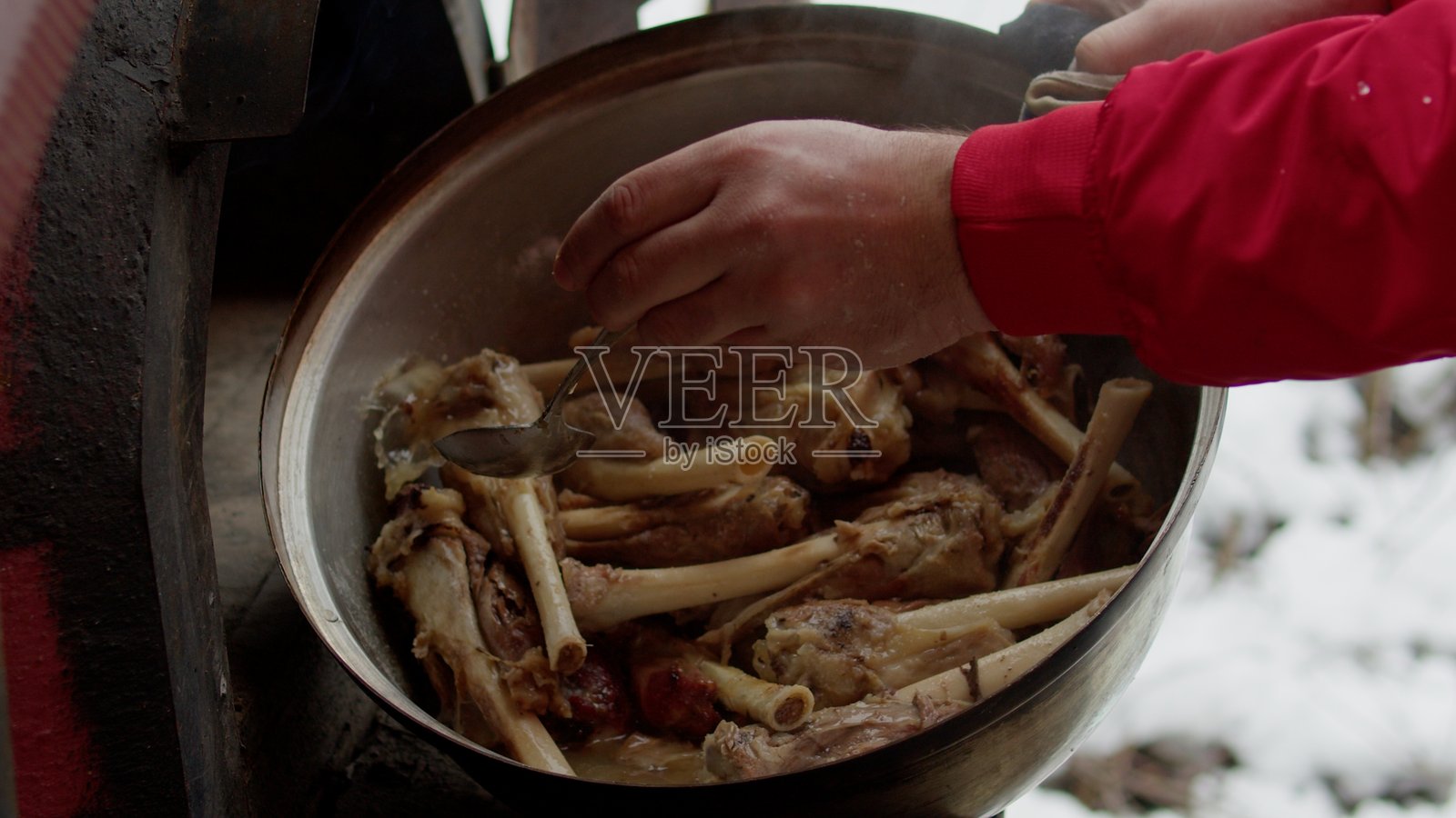 在雪地中户外准备传统菜肴。照片摄影图片