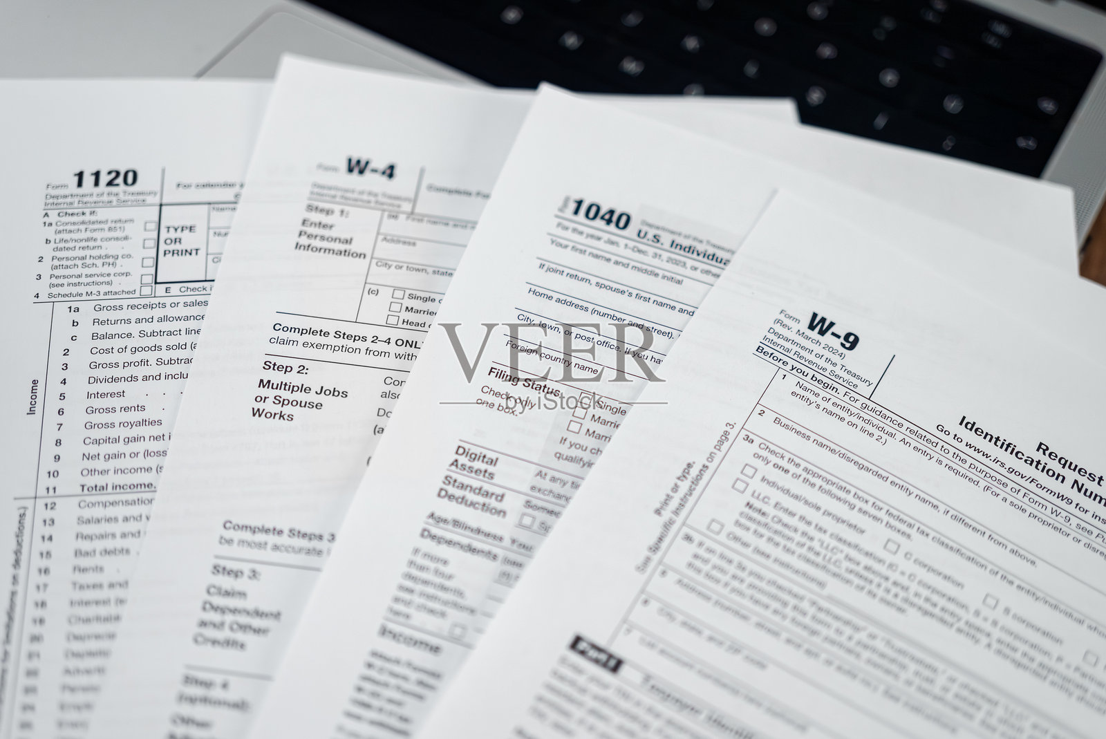 各种税务表格放在笔记本电脑上，旨在帮助个人在税务系统中实现特定目的。照片摄影图片