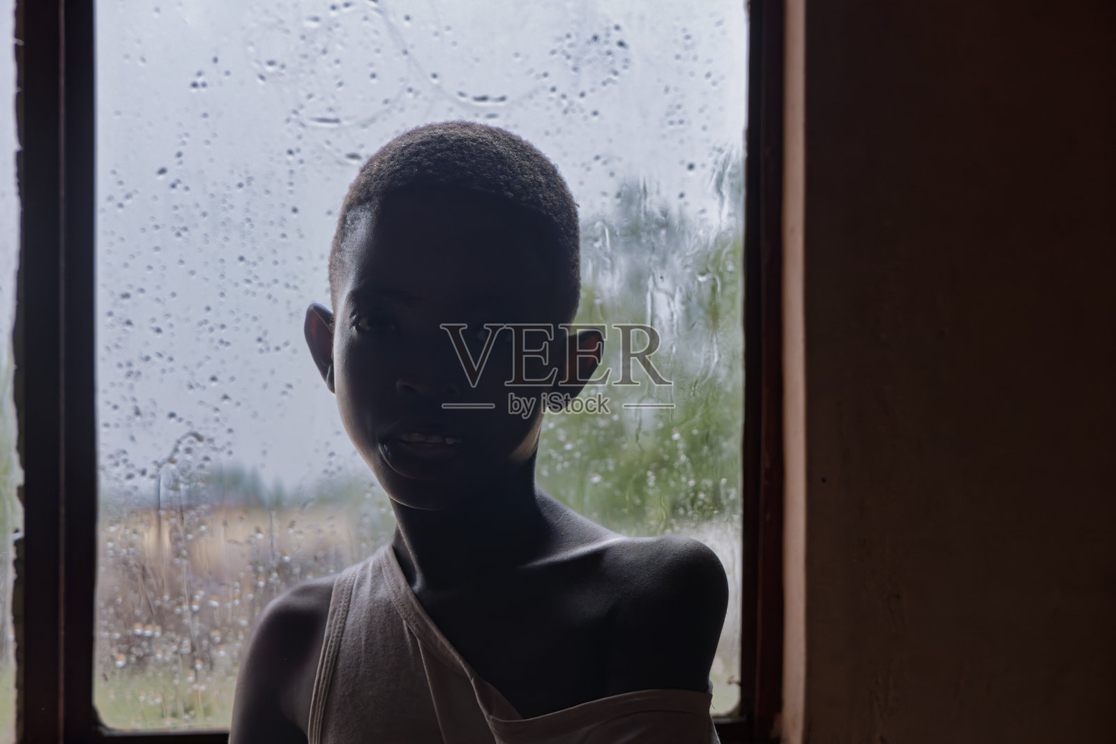 贫困家庭中的非洲女孩剪影，表情严肃照片摄影图片