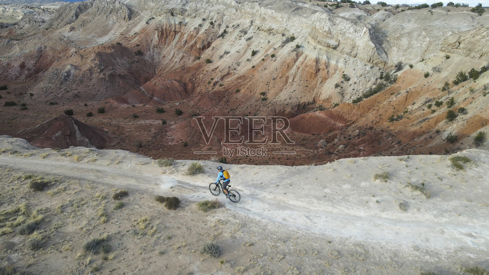 山地自行车手沿着沙漠/山脉小径骑行的鸟瞰图照片摄影图片