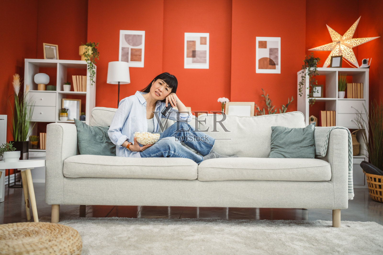 专注的成熟日本女性在电视上仔细观看电影照片摄影图片