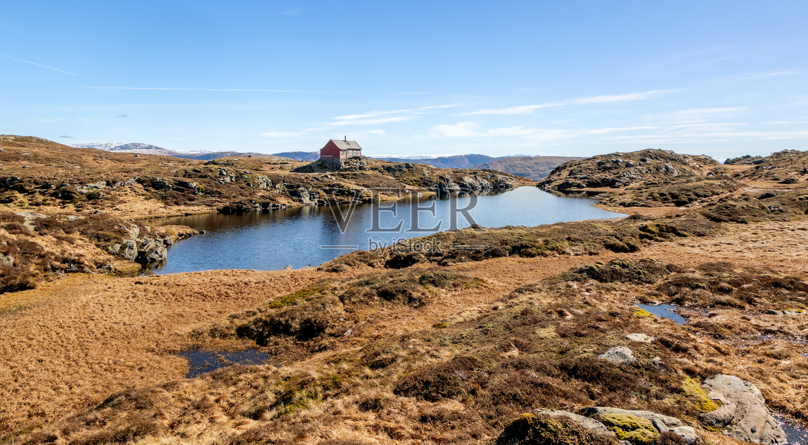 春季的卑尔根附近，红色小屋与湖泊相映衬的山地风景照片摄影图片