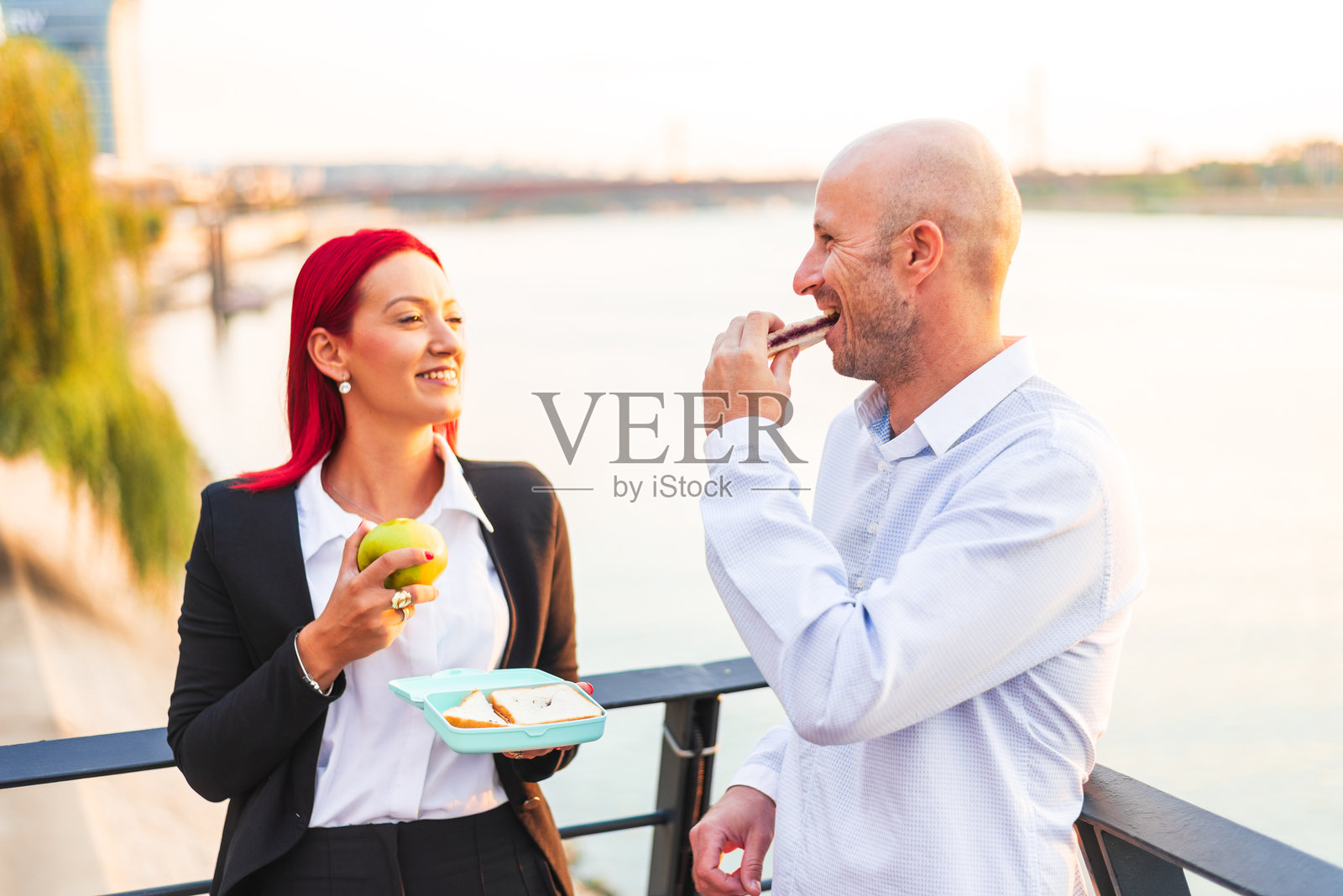 商务人士在河边户外享用午餐休息时间照片摄影图片