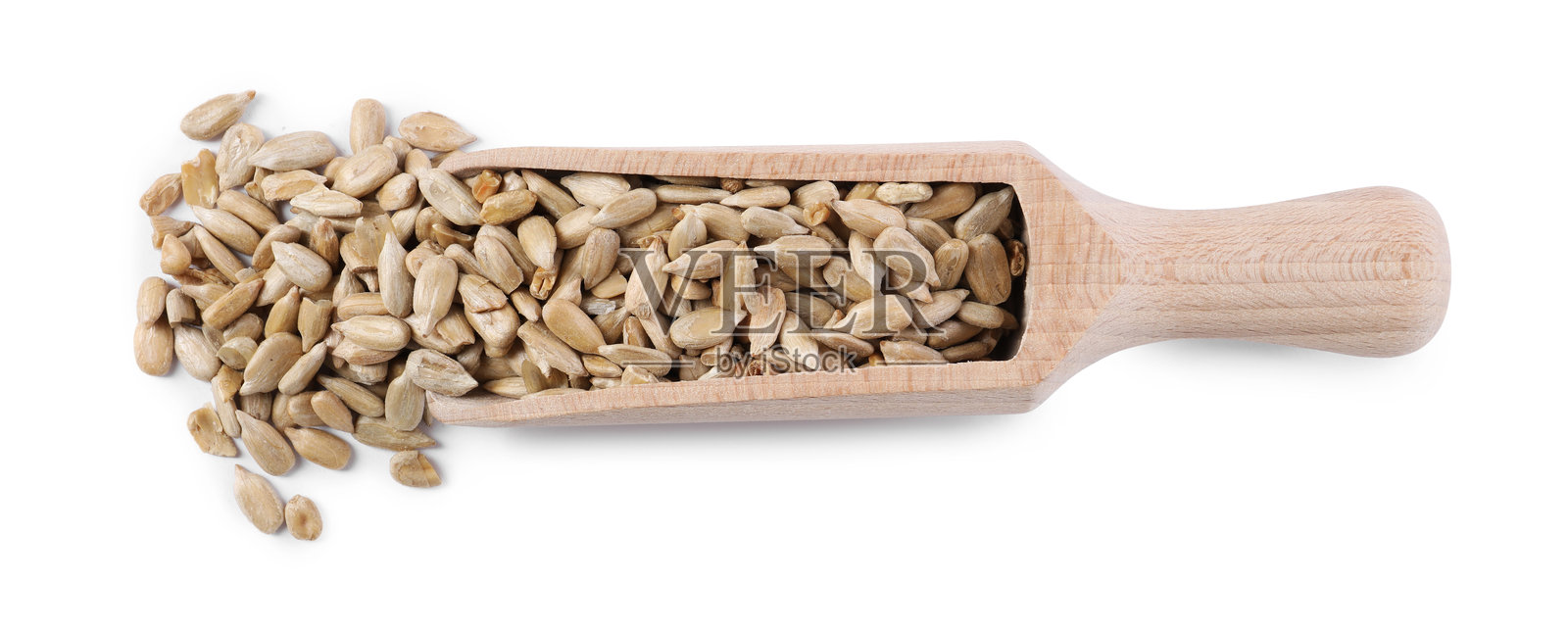 白色背景上木勺中的剥皮葵花籽，俯视图照片摄影图片