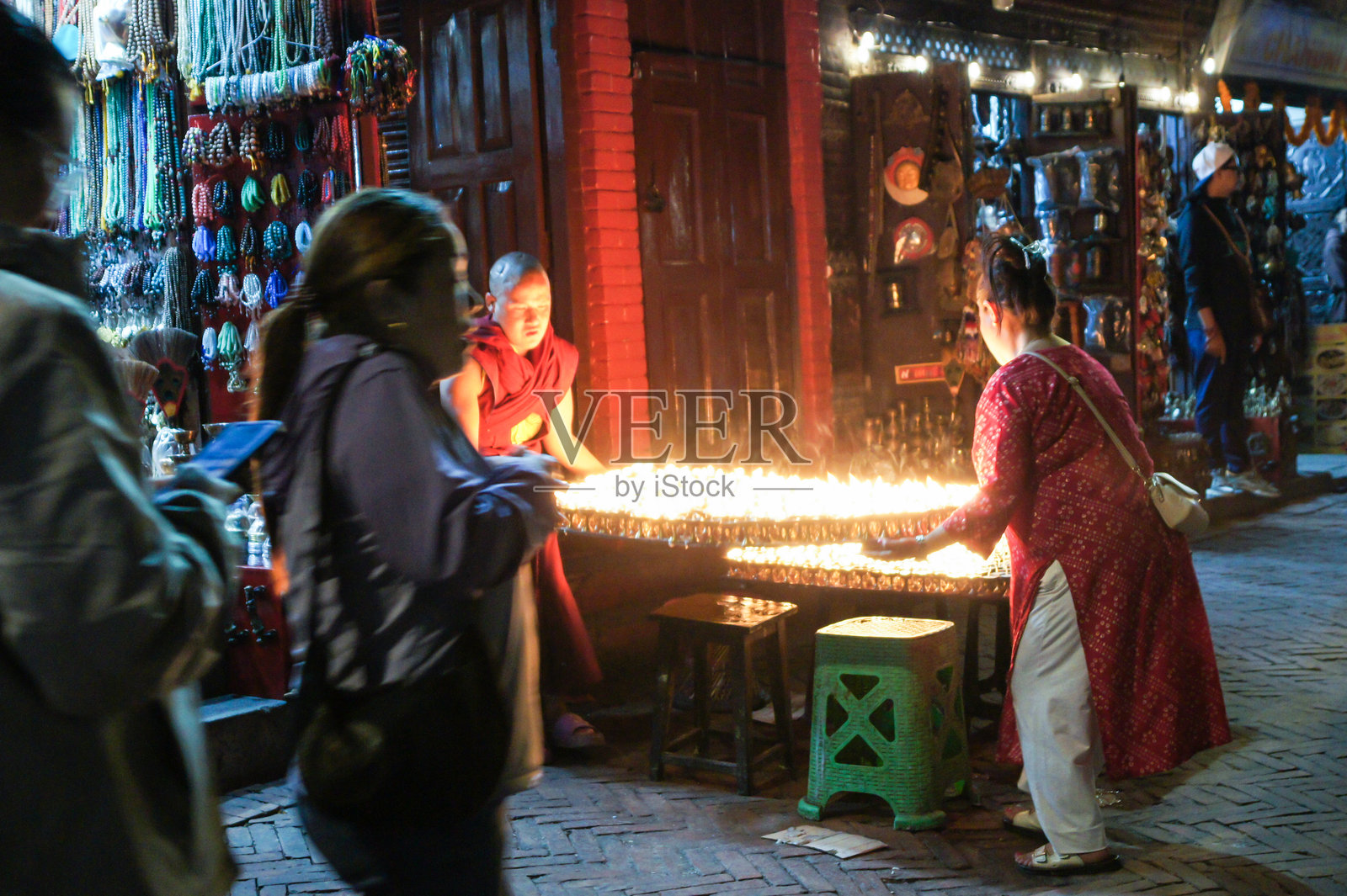僧侣们举起一个装有燃烧蜡烛的大托盘。照片摄影图片