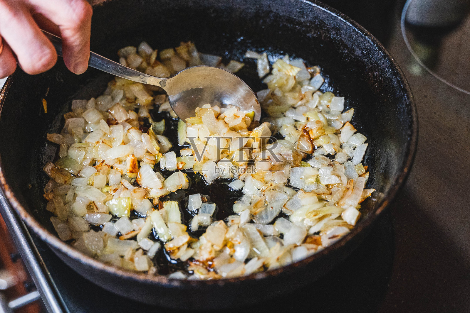 厨师在热油中煎炒切碎的洋葱照片摄影图片