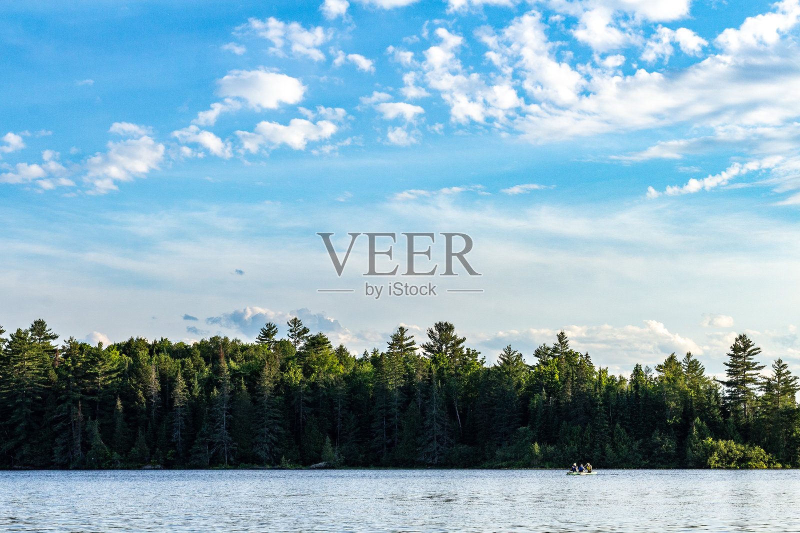 宁静湖面上小船与蓝天下的森林美景照片摄影图片