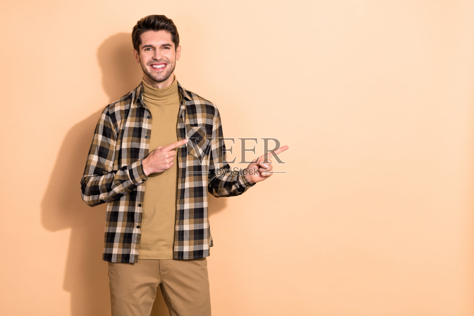 积极的推广交易员指向空白广告空间，建议选择孤立的柔和色彩背景照片摄影图片