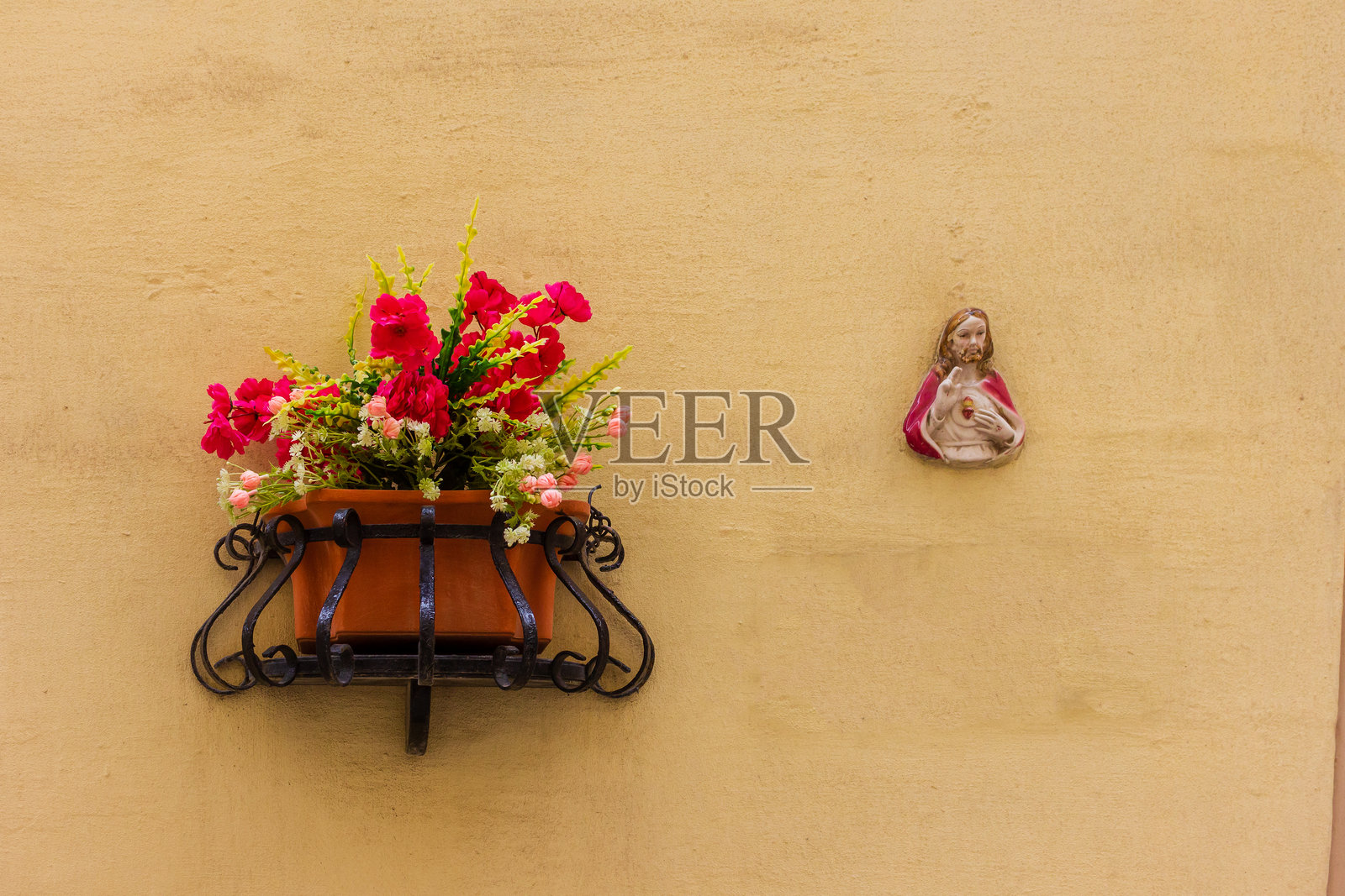 米色表面上的装饰墙，花盆和宗教图标照片摄影图片