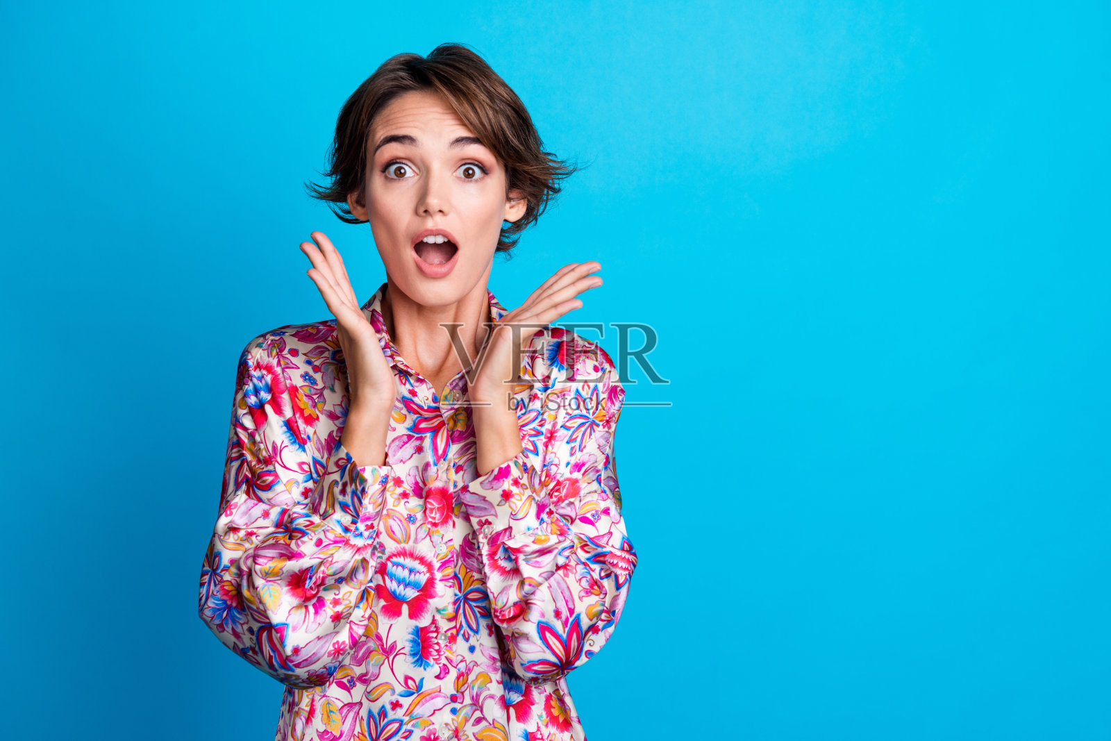 兴奋快乐的女孩双手捂脸，穿着时尚衣服，庆祝黑色星期五折扣，背景为蓝色空白空间。照片摄影图片