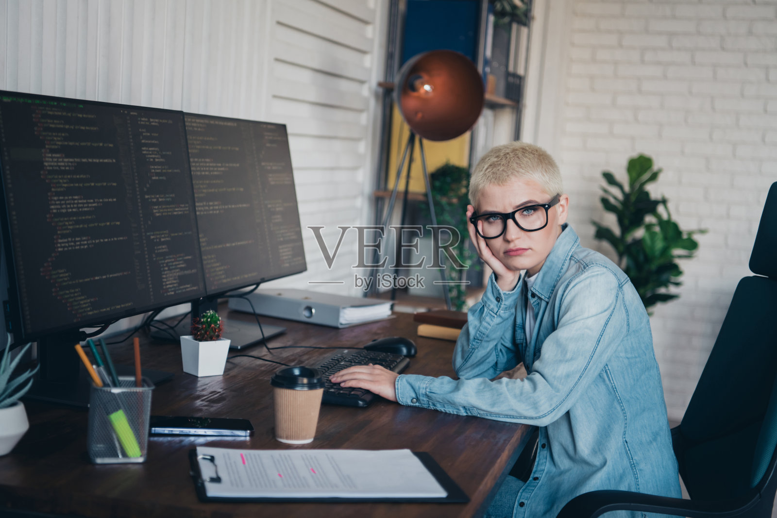 年轻女性程序员在家办公，使用电脑和编程软件照片摄影图片