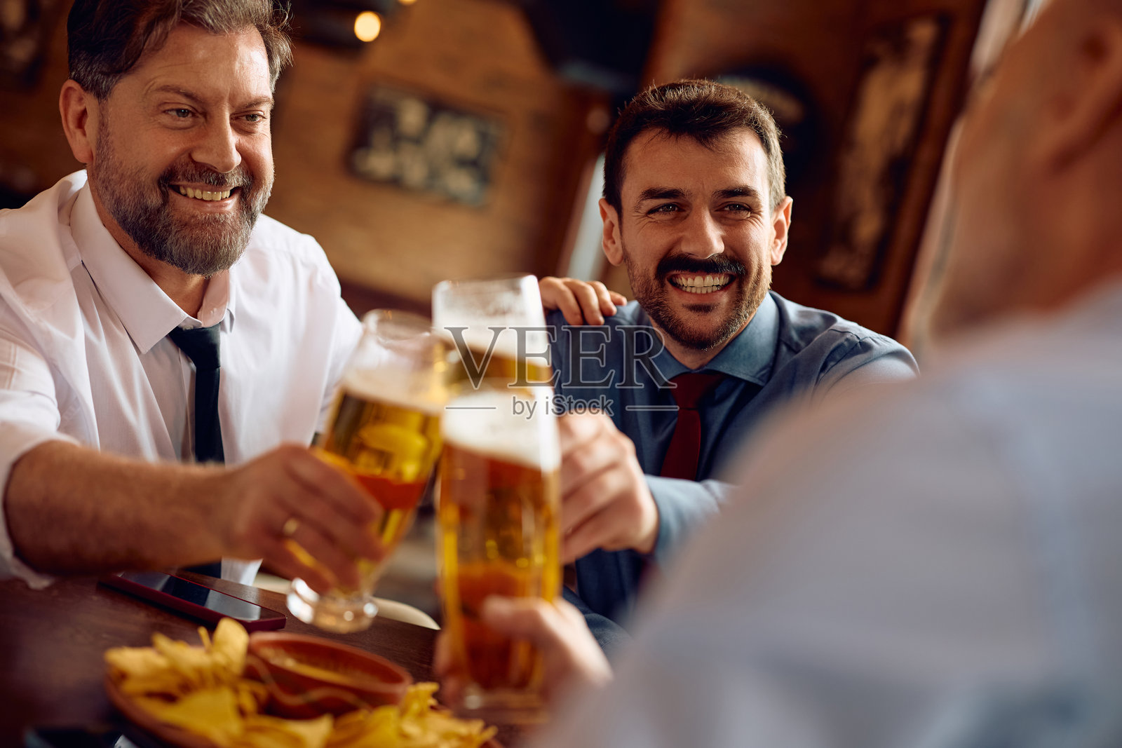 快乐的企业家们在酒吧庆祝他们的商业成功。照片摄影图片