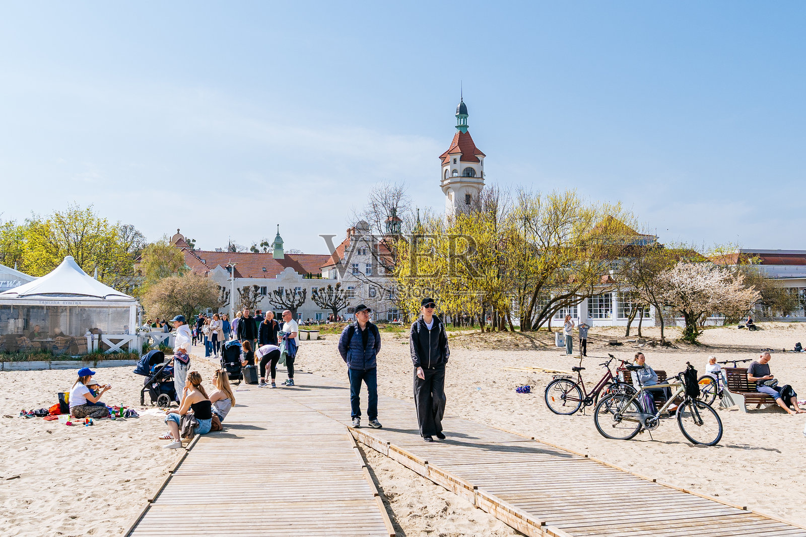 索波特灯塔附近的海滩，人们在散步，骑自行车的人在附近休息照片摄影图片