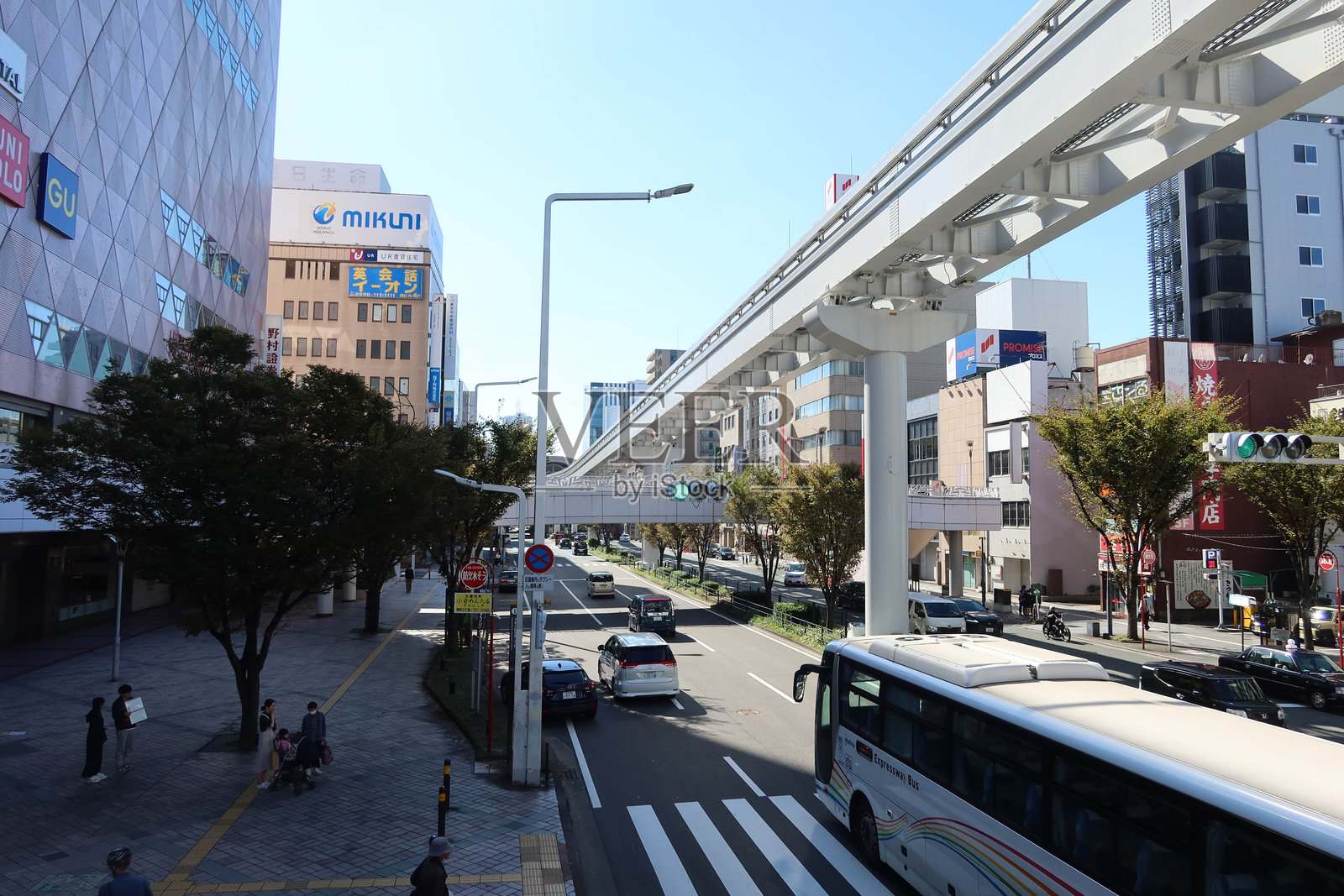 高架单轨铁路系统在繁忙的街道上方运行。在单轨铁路下方,可以看到汽车沿着道路行驶和高楼大厦。照片摄影图片