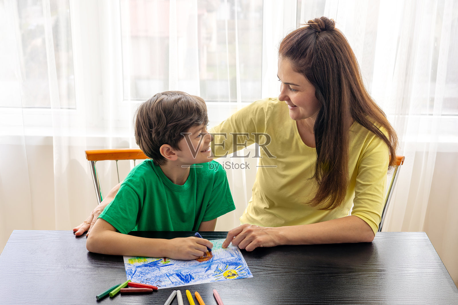 母亲与儿子一起绘画 - 在家与五彩蜡笔的家庭创意时光。儿童艺术疗法。儿童心理学，孤独症，注意力缺陷多动障碍。父母与孩子的优质时光。留白空间。照片摄影图片