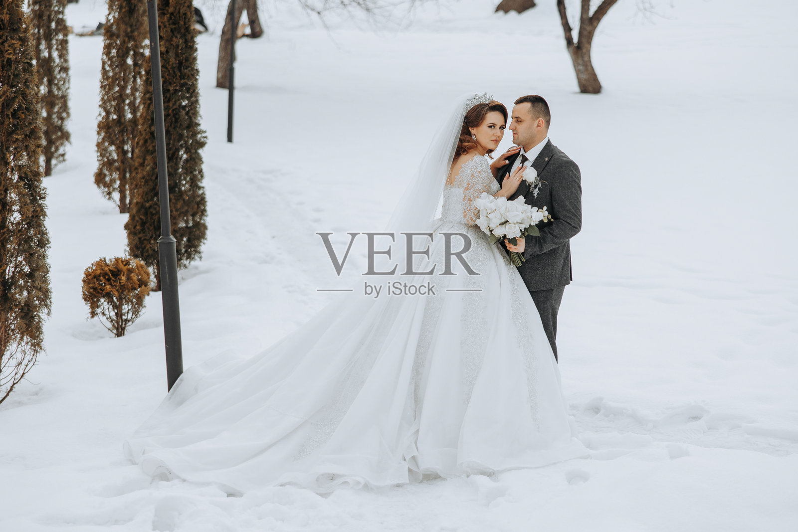 一对新郎新娘站在雪中照片摄影图片