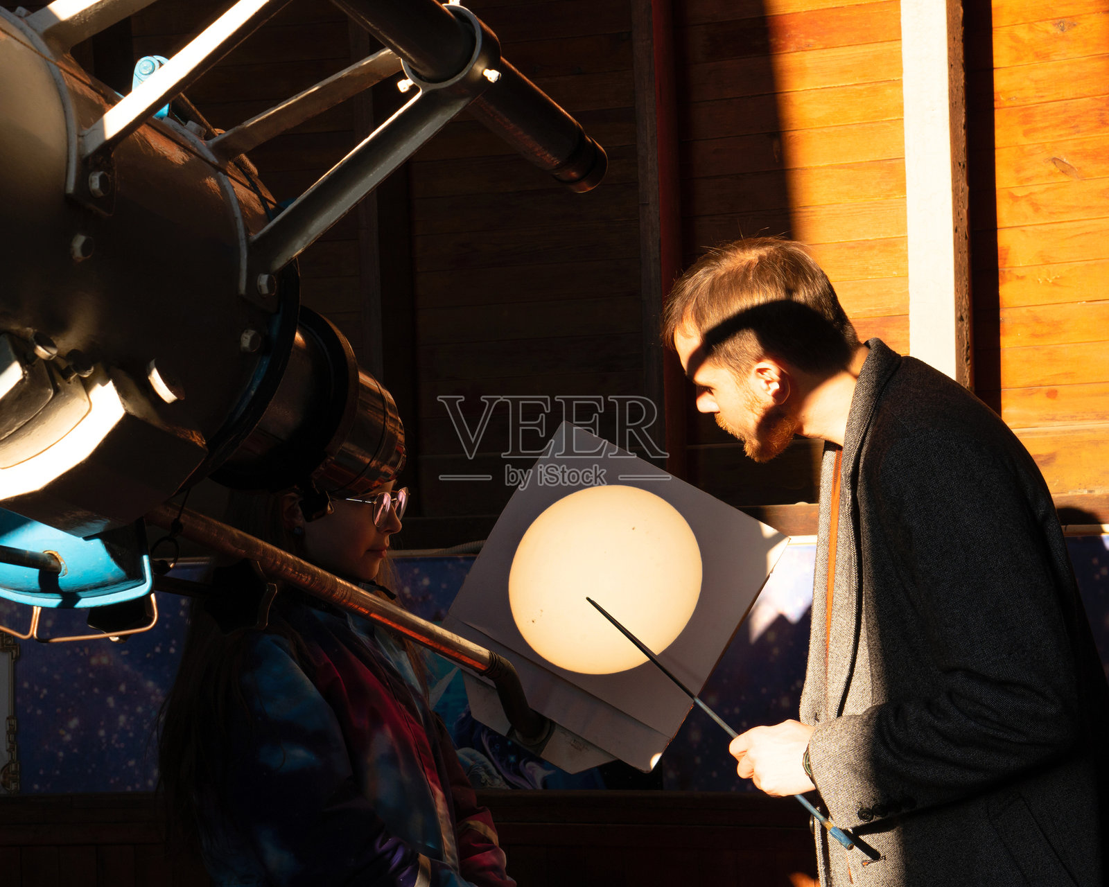 男人和女孩观察望远镜投影的太阳图像。照片摄影图片