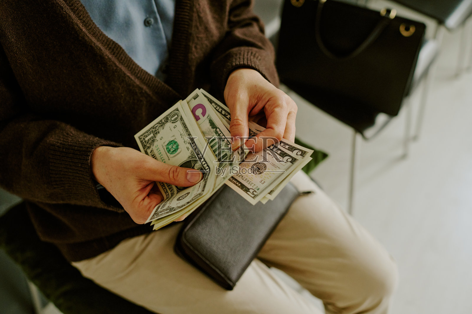 坐着数钱，旁边有一个皮包照片摄影图片