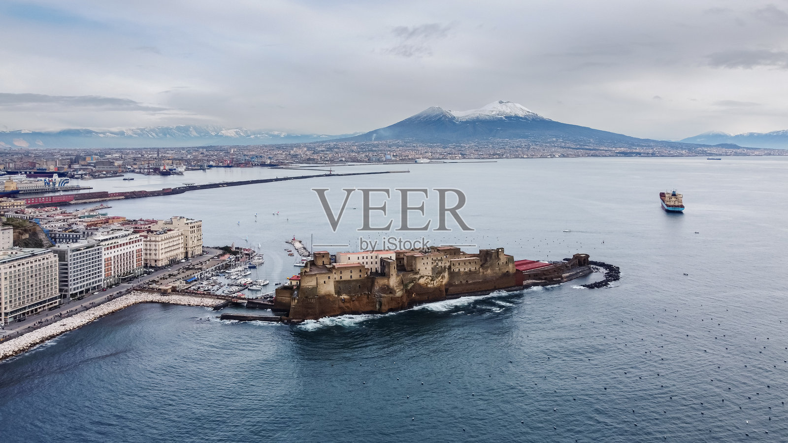 日落时分，令人惊叹的那不勒斯空中视角，标志性的维苏威火山高耸于城市之上，海滨的蛋堡骄傲地矗立。照片摄影图片