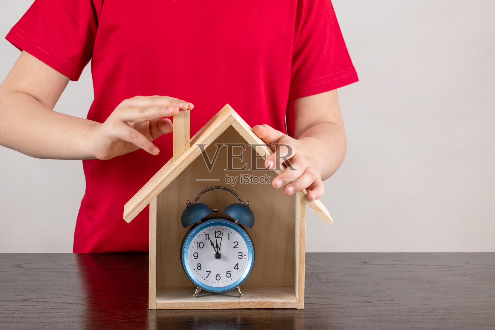 孩子们手中拿着象征性的木屋和闹钟照片摄影图片