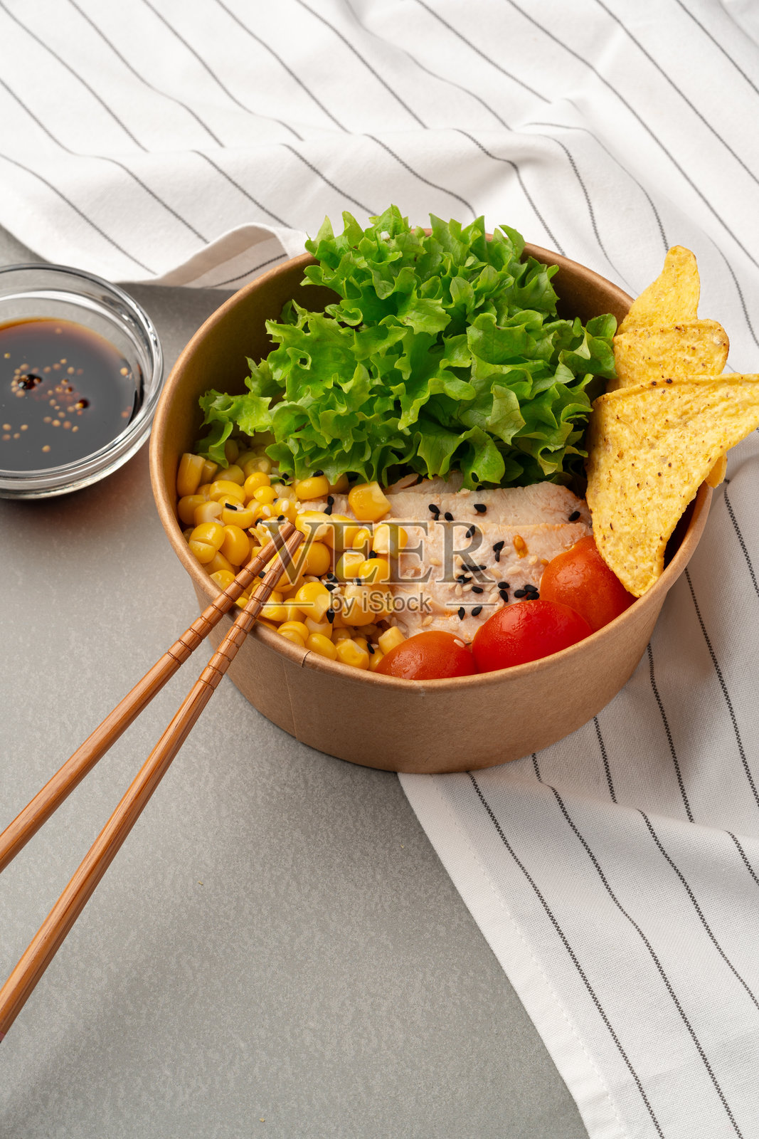 色彩缤纷的新鲜食材碗，搭配一旁的蘸酱，享受温馨的环境照片摄影图片