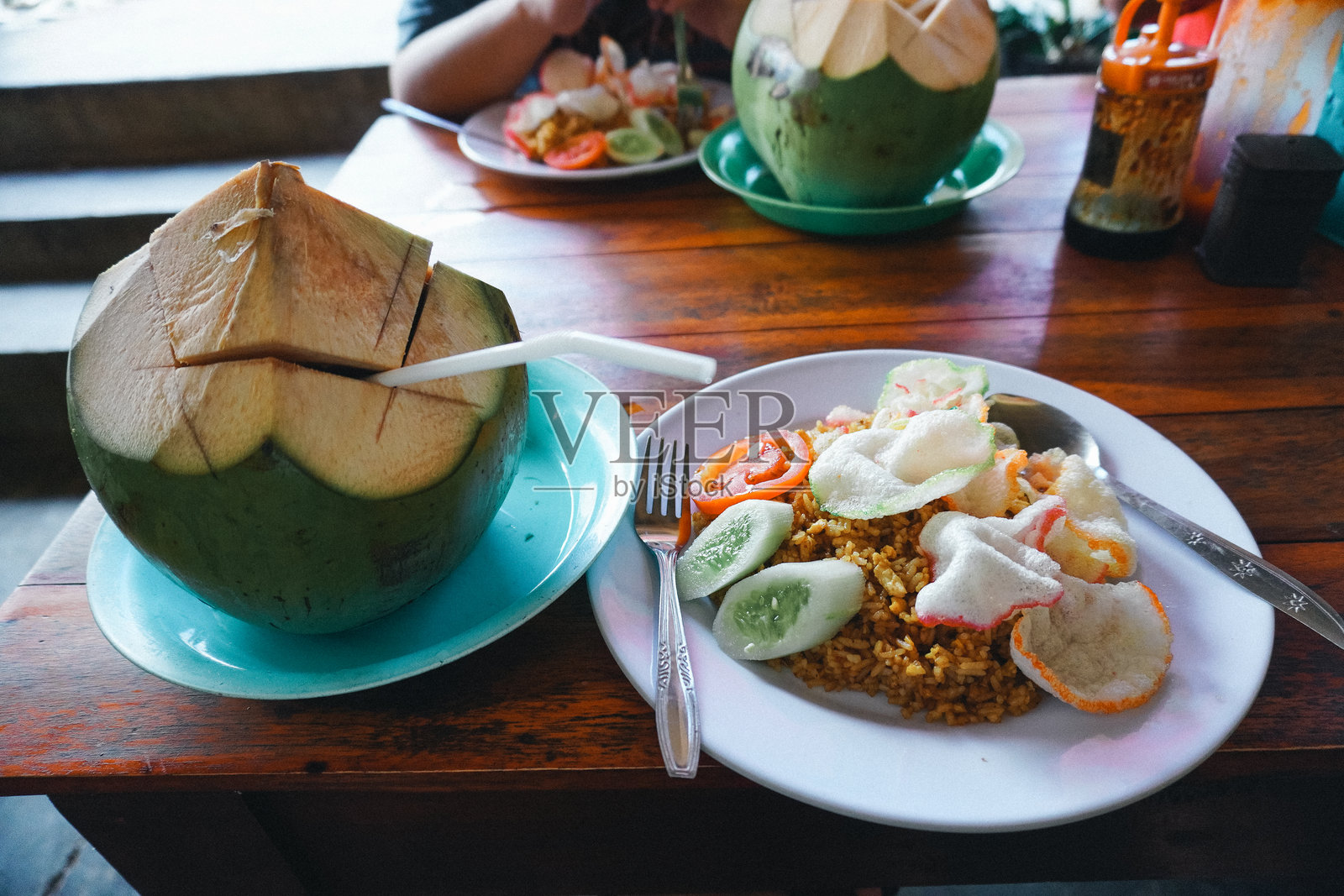 在户外咖啡馆享用印尼炒饭和新鲜椰子水照片摄影图片