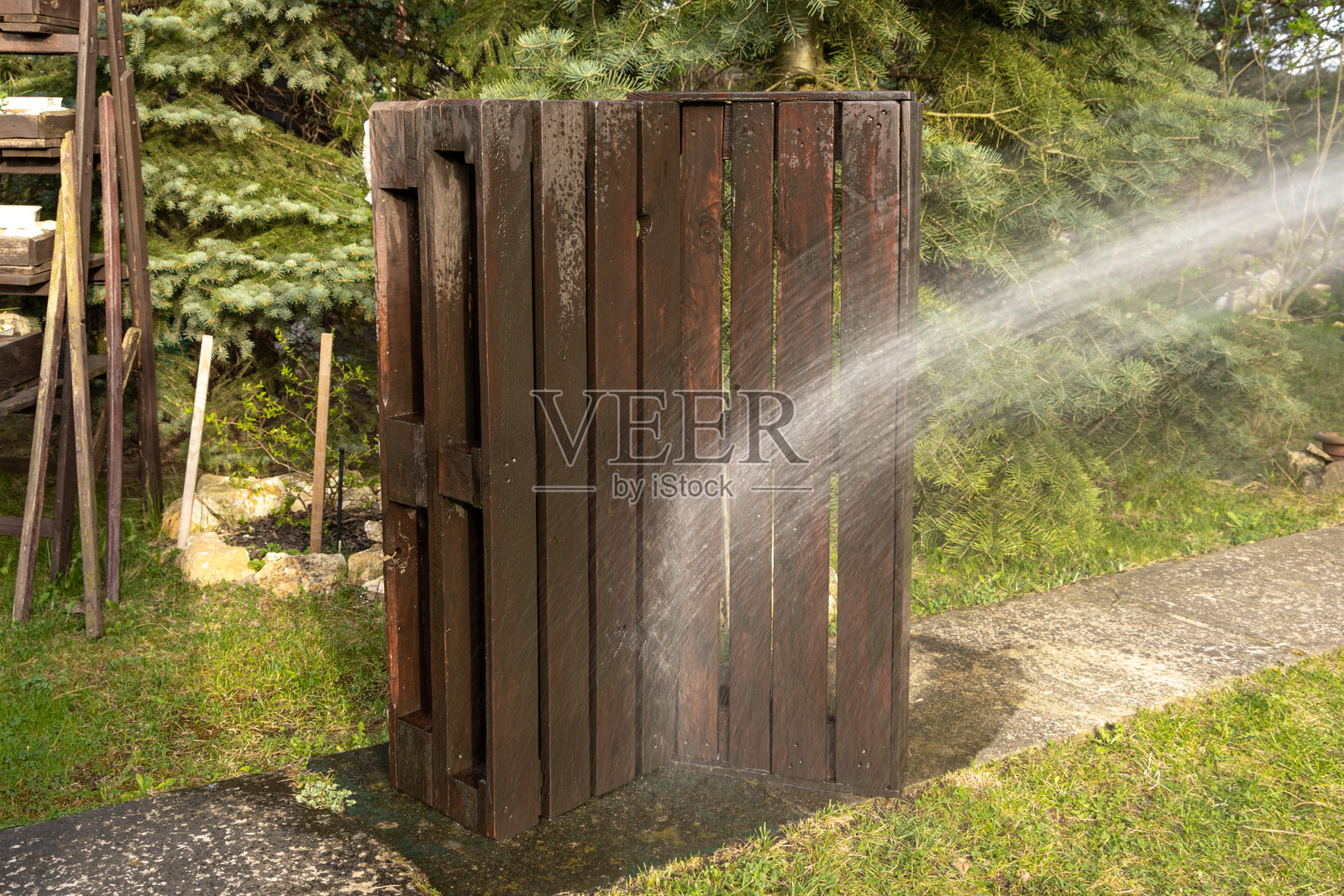 用肥皂水清洗用托盘制作的木质花园家具，家具翻新。照片摄影图片