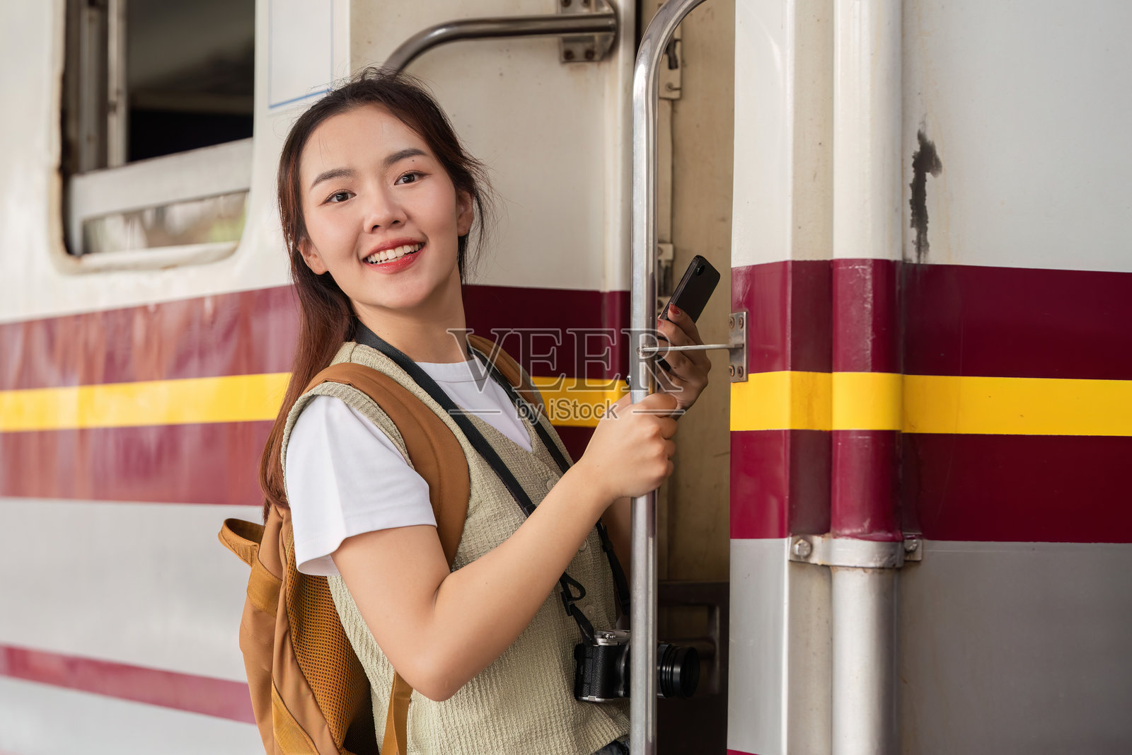 旅行与新开始。一位女性自信地登上火车，准备开始她的旅程。照片摄影图片