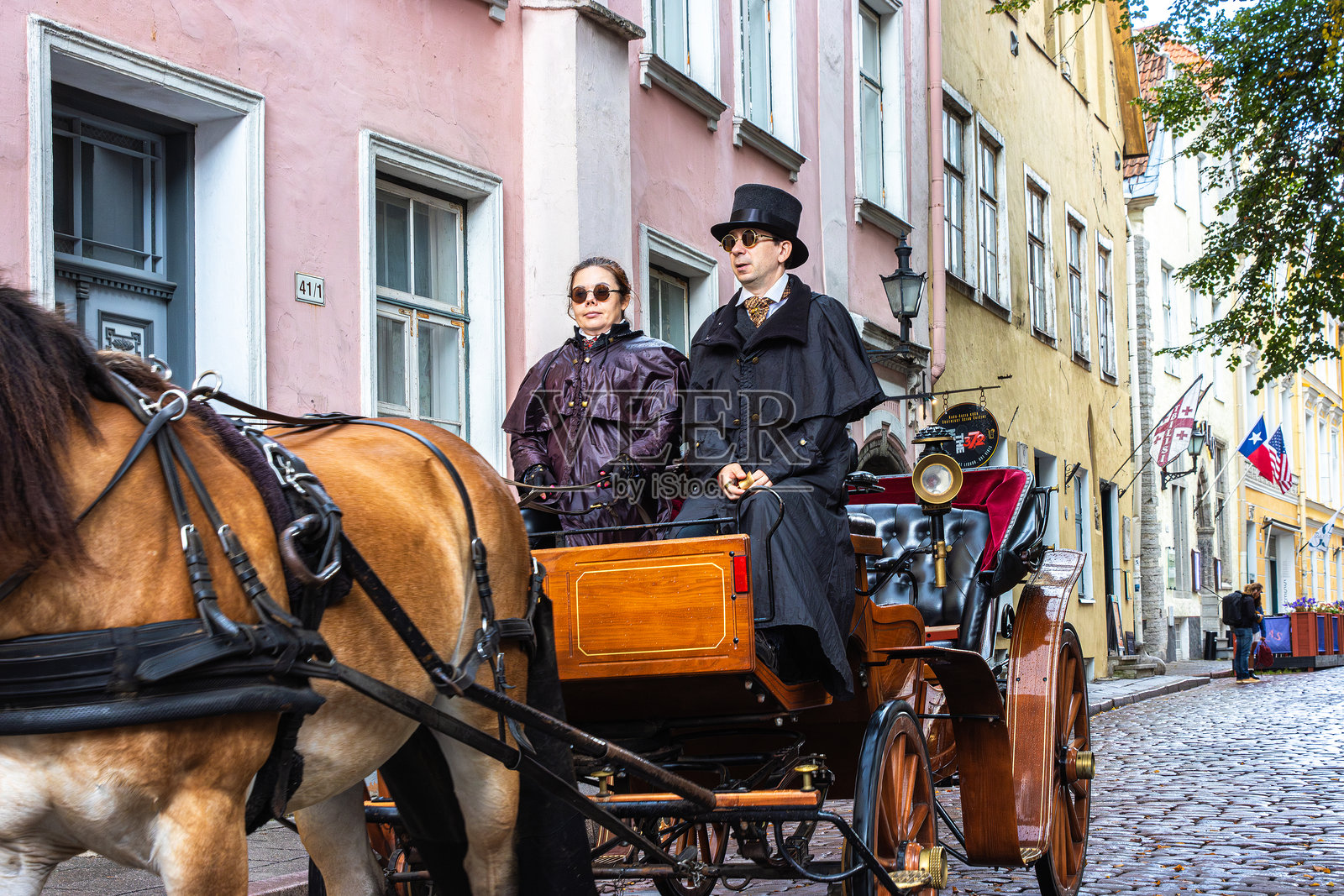 塔林老城的皮克街上有一辆复古的马车。爱沙尼亚首都的传统马车导览游，马车夫身穿历史服装。照片摄影图片