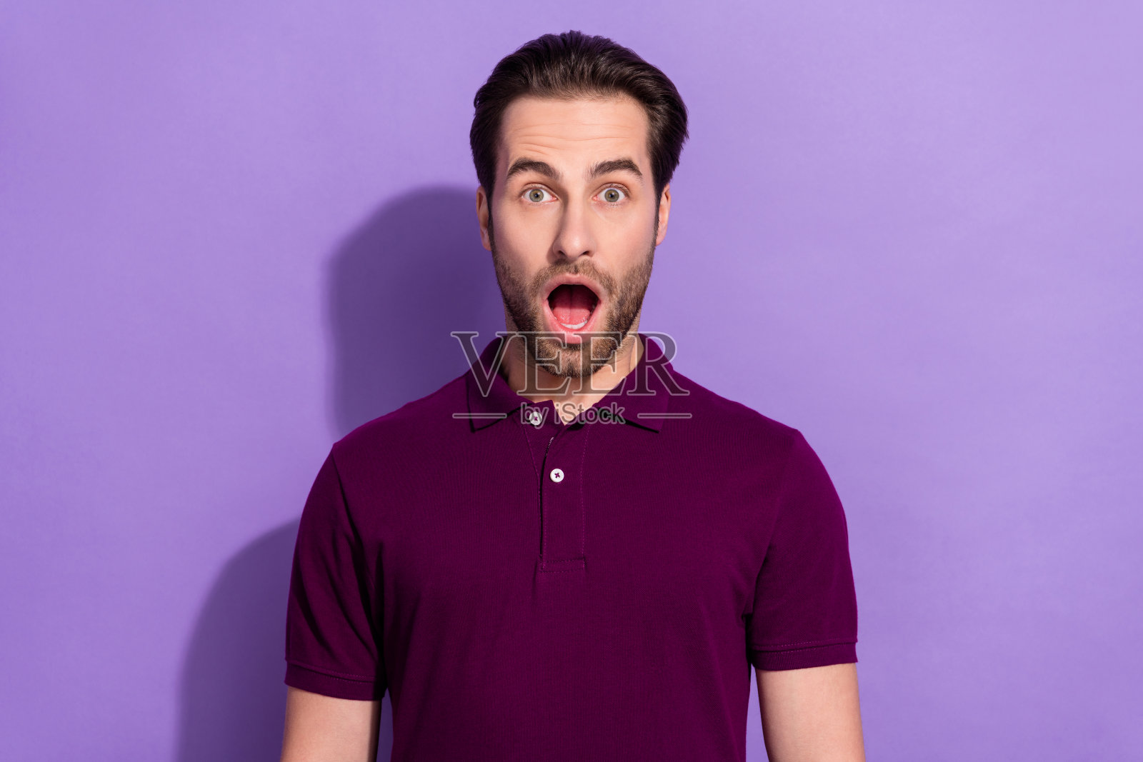 惊恐、惊讶、印象深刻的男性肖像，因陷入大麻烦而大喊，背景为紫色。照片摄影图片