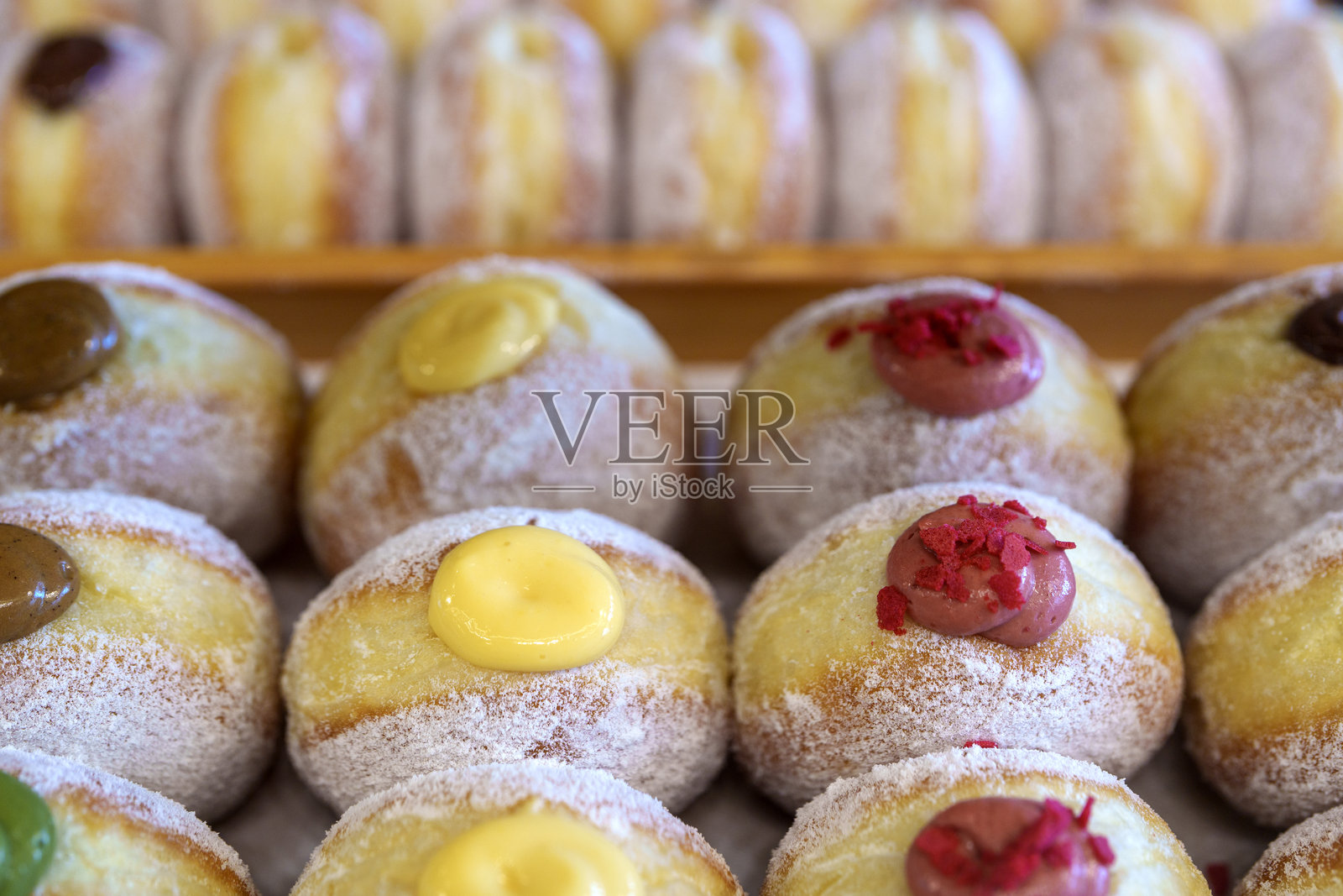 色彩缤纷的填充甜甜圈在糕点托盘中照片摄影图片