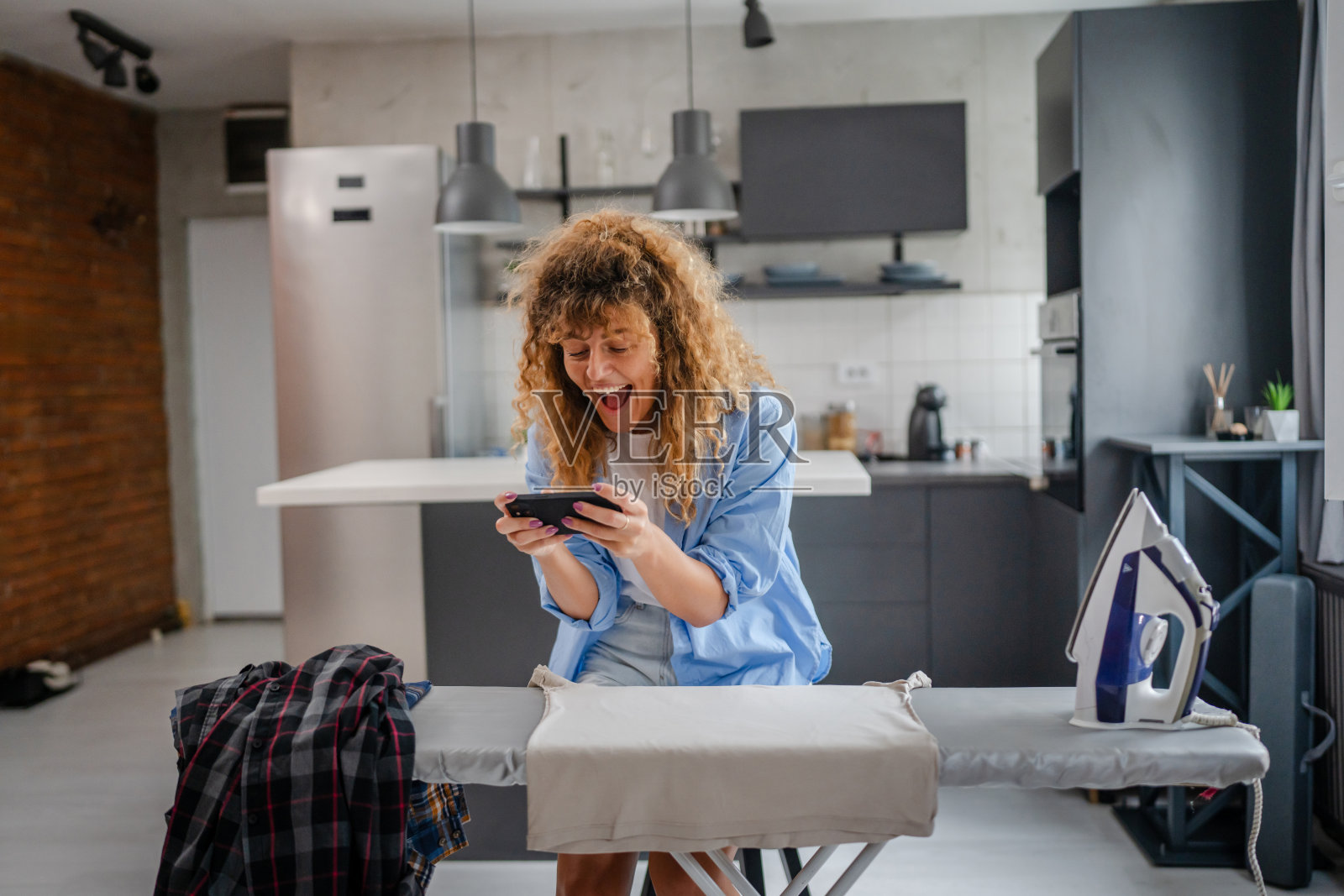年轻女性在家中玩手机游戏照片摄影图片