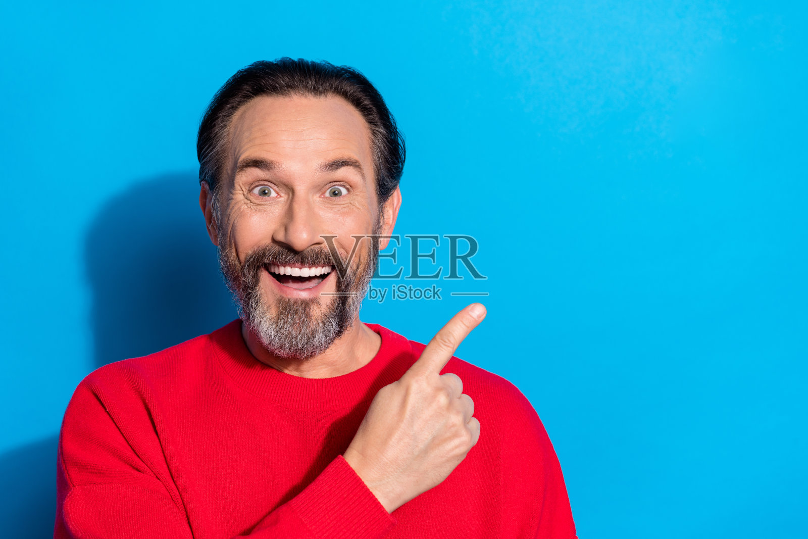 开心、惊讶的男士在蓝色背景上展示产品，建议选择物品。照片摄影图片
