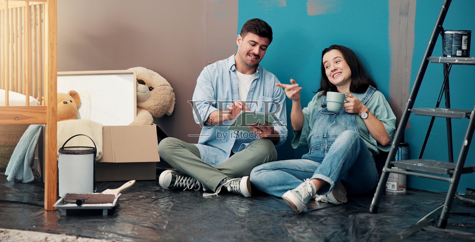 家庭装修，父母与平板电脑的夫妻，讨论和规划装饰。数字布局，父母或男性与女性在地板上，科技和电子商务选择，DIY，休息和产假。照片摄影图片