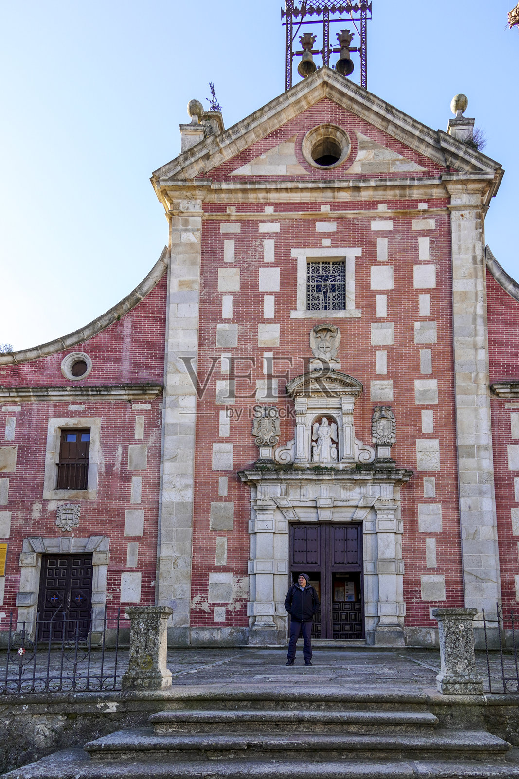一名男子站在西班牙卡塞雷斯赫尔瓦斯的一座修道院门口。照片摄影图片